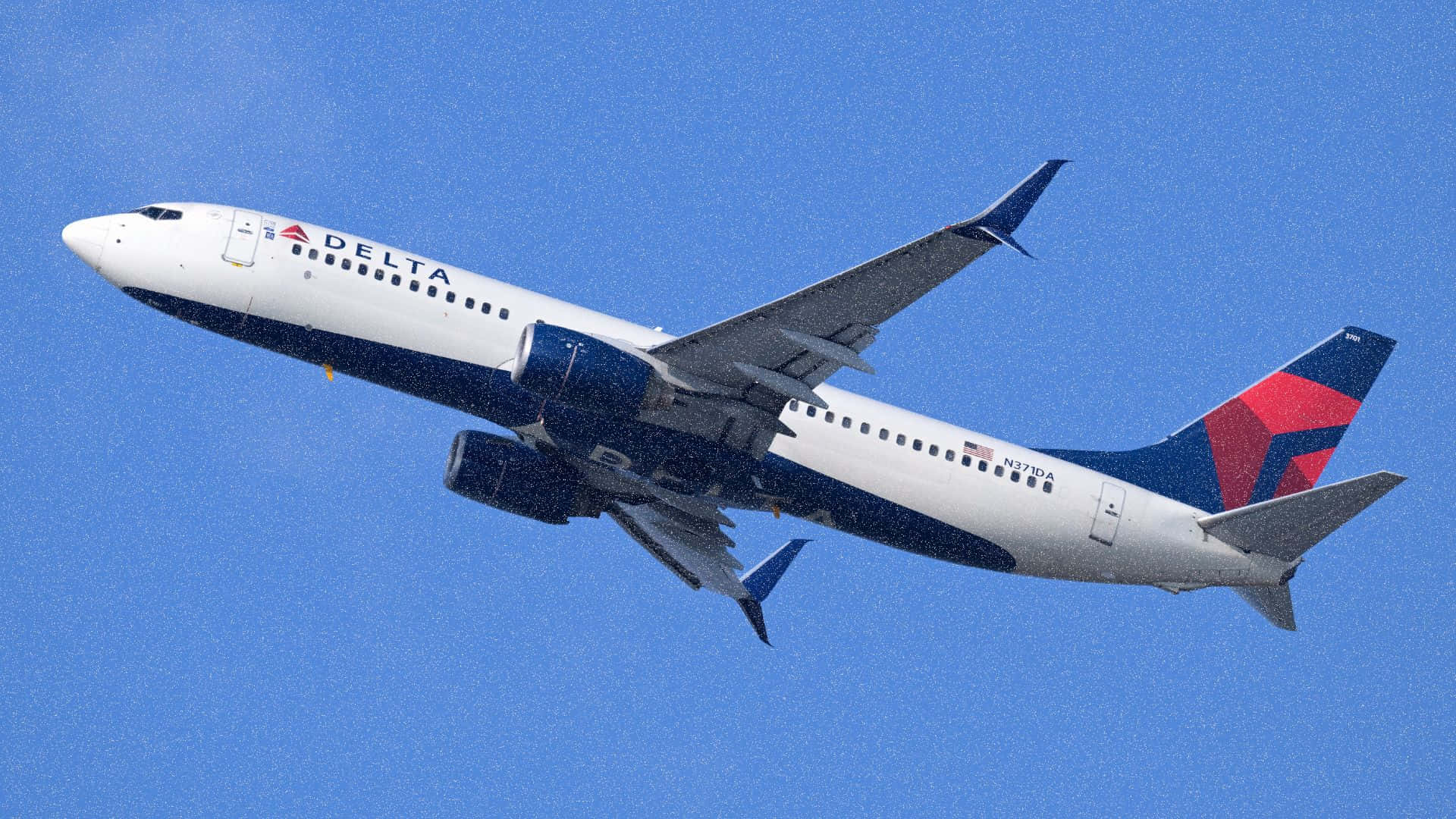  壁紙 — 一架達美航空波音737在晴朗的藍天中翱翔，機翼向上傾斜。