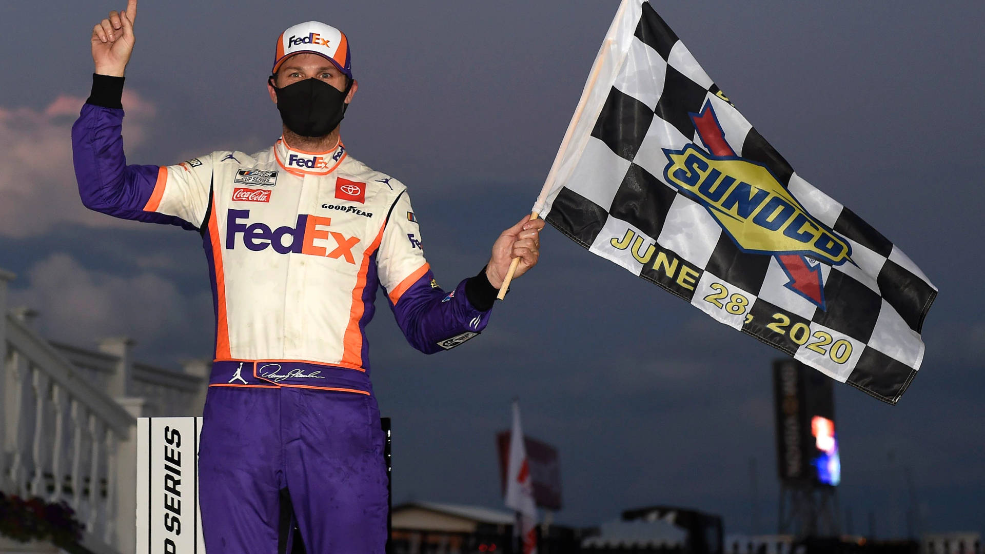 NASCAR車手在黃昏比賽勝利後手持格仔旗
