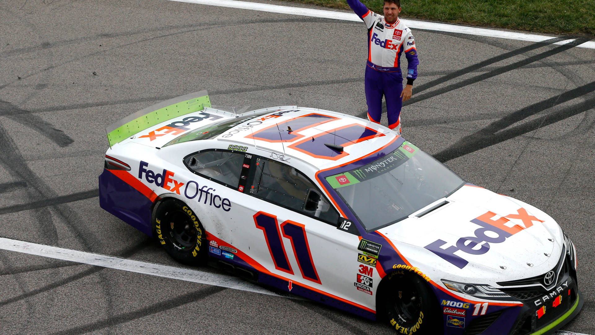 NASCAR車手在賽道上於他的FedEx Office賽車上慶祝勝利。