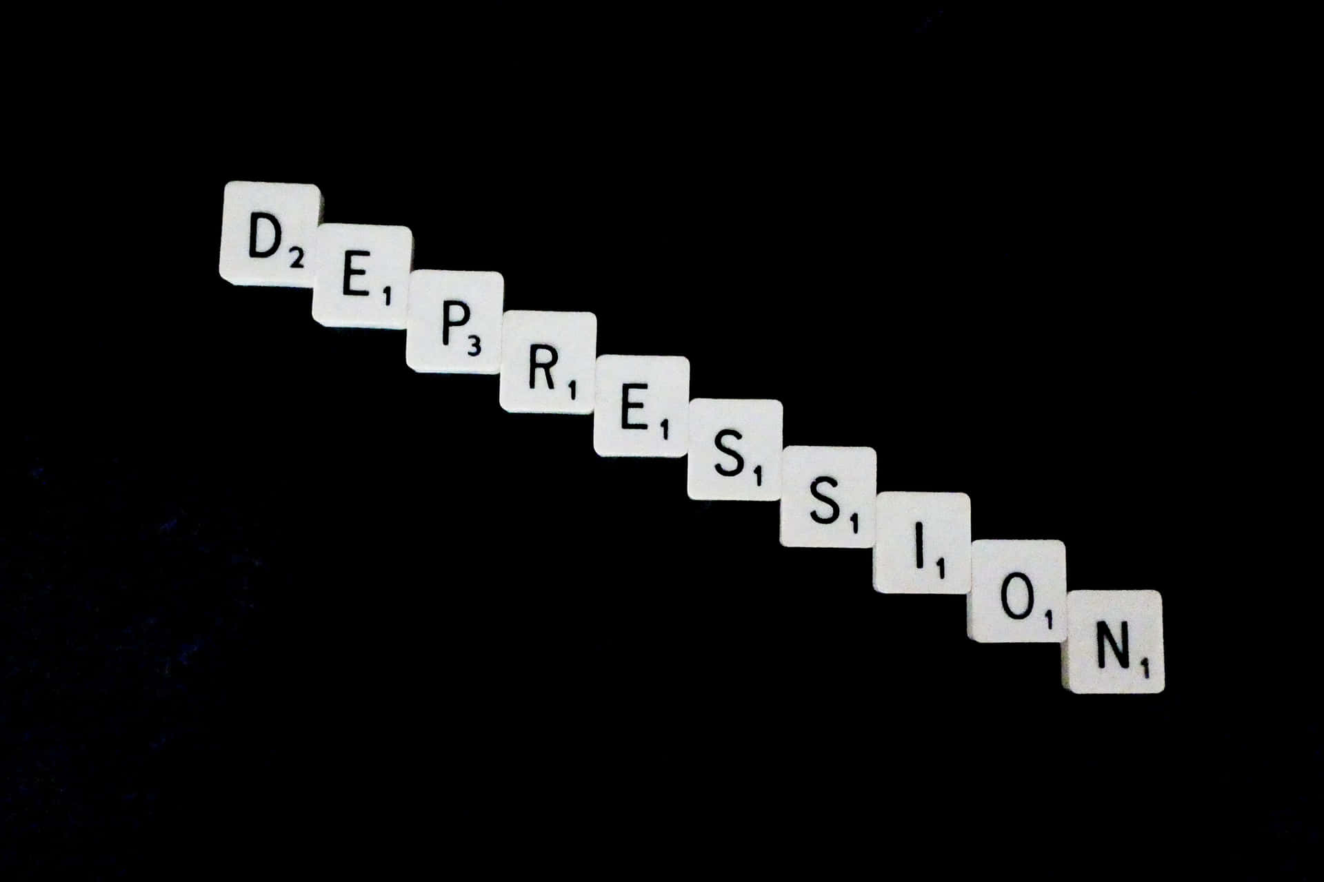 白色 Scrabble 字母磚在黑色背景上拼出 depression