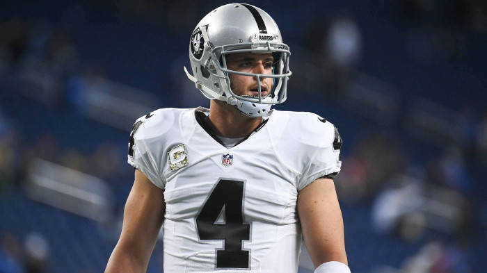 NFL四分衛在夜間足球場上穿著Raiders球衣4號。