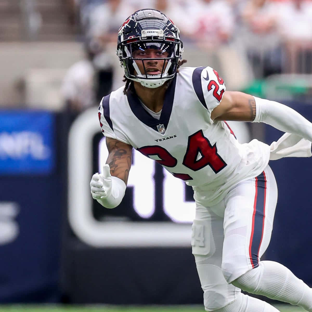 Derek Stingley Jr 賓州海鷹隊新秀 壁紙 — 一位身穿白色球衣的侯斯頓德州人隊美式足球員，帶著專注的強度在球場上動態衝刺。