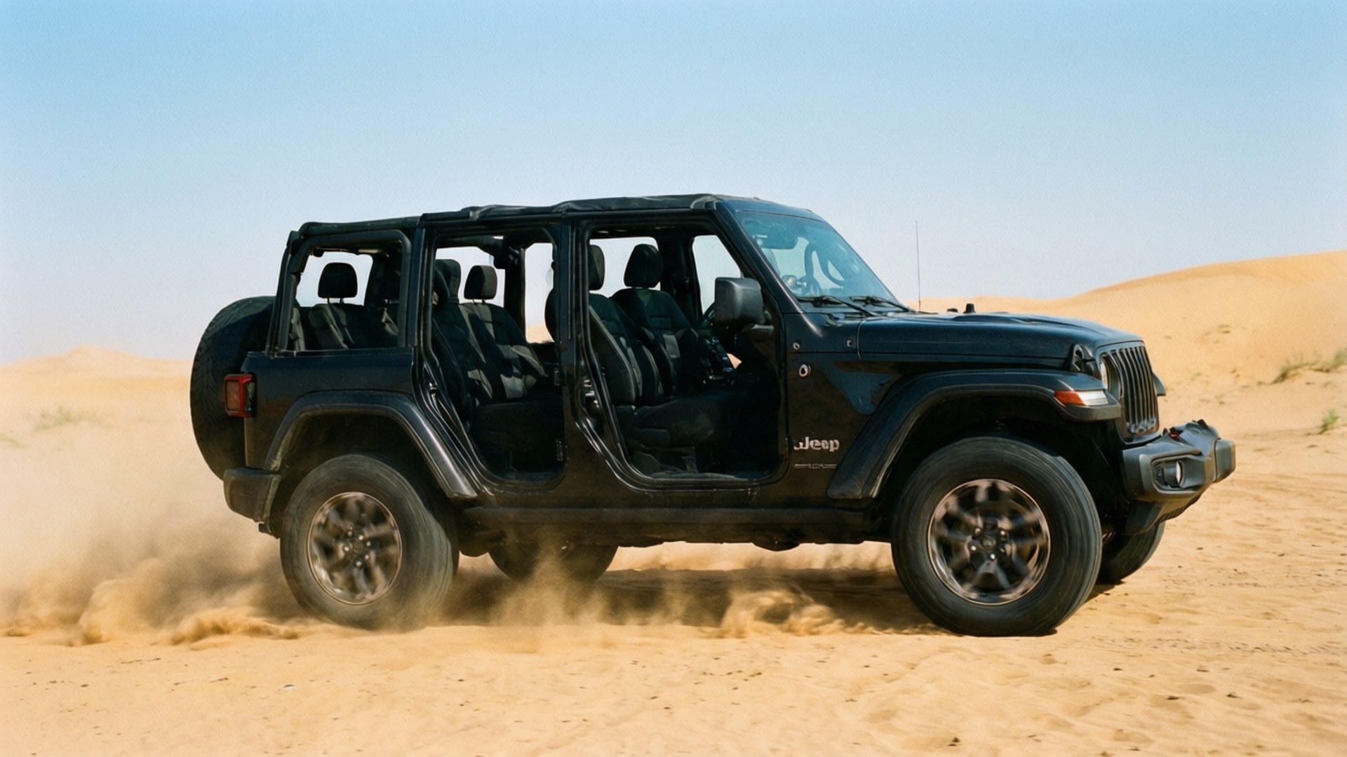 黑色Jeep Wrangler無門車在沙漠沙丘上行駛