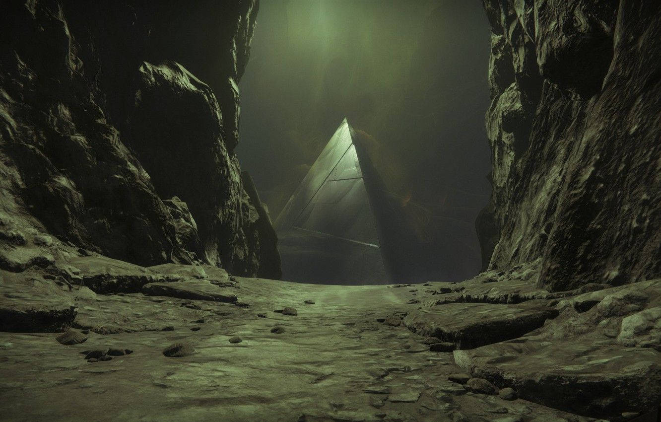 《Destiny 2：Shadowkeep》金字塔塔樓 壁紙 — 一條狹窄岩石峽谷籠罩在詭異的綠光中，盡頭處一座神秘金字塔微微發光。