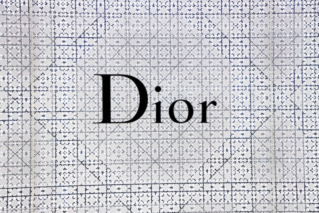 以Dior展現無瑕時尚魅力 壁紙 — Dior 標誌以粗體黑色字體居中於白色背景上，帶有複雜的藍色幾何網格圖案。