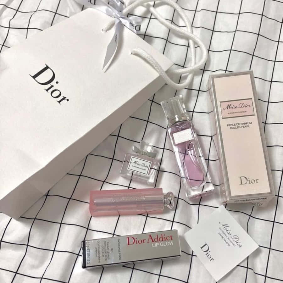 奢華再升級：Dior勾勒新時代願景 壁紙 — Dior 美容產品，包括香水、唇彩和購物袋，整齊地排列在黑白格紋布料上。