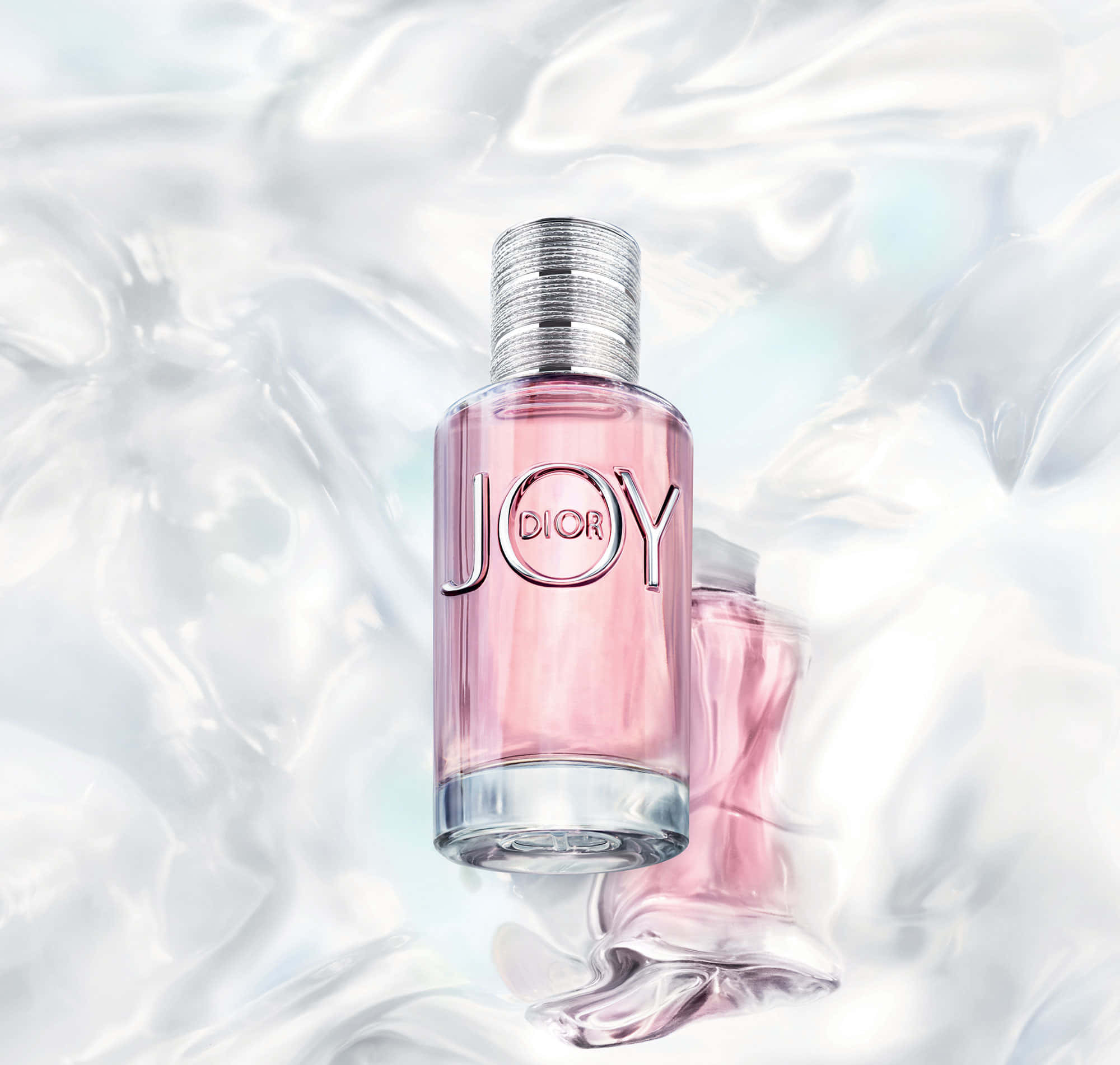 Dior的典雅風采 壁紙 — 一個粉紅色的Dior Joy香水瓶漂浮在旋轉的彩虹色液體中，附近有另一個瓶子部分浸沒。