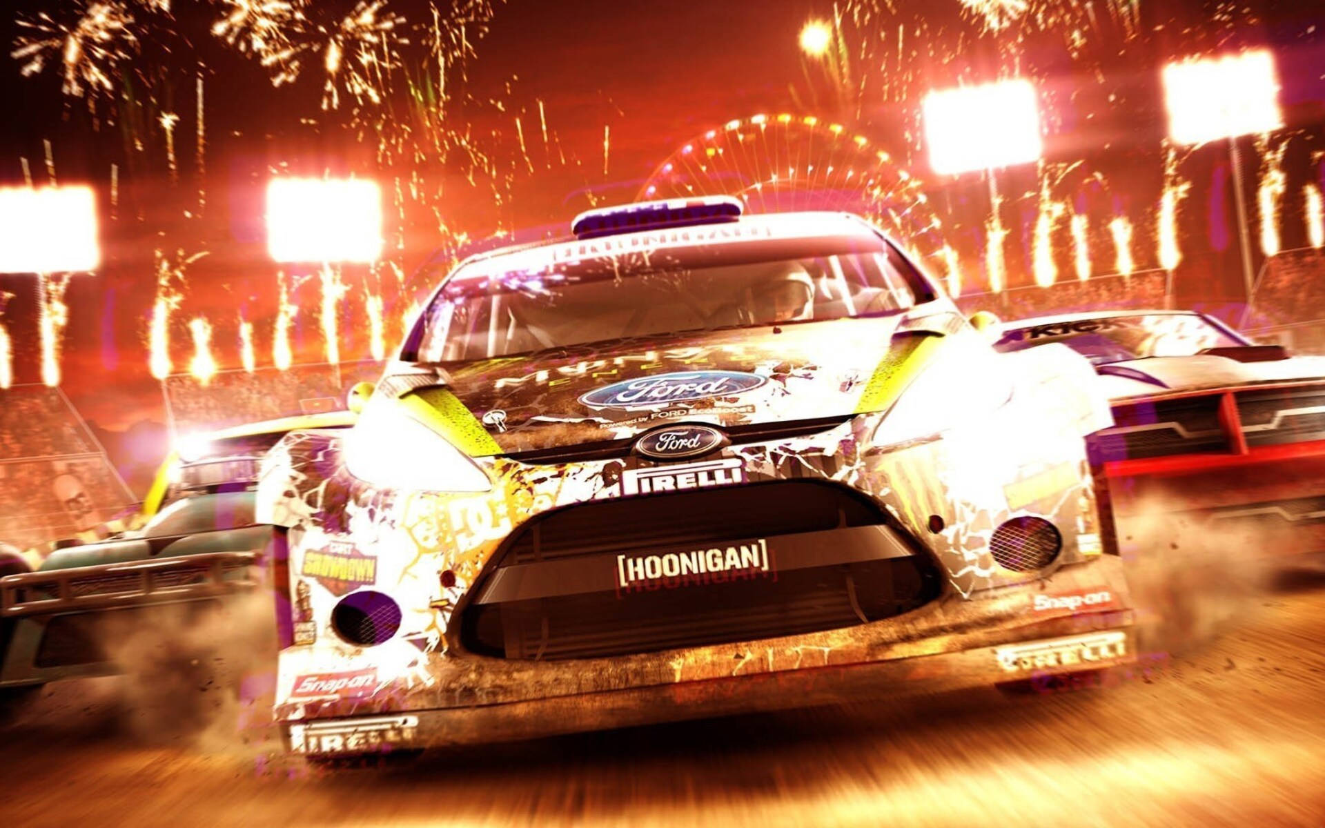 Dirt 3 爆炸賽道行動 壁紙 — 一輛帶有 'Hoonigan' 品牌的福特拉力賽車在煙花和體育場燈光下於夜間泥地賽道上飛馳。