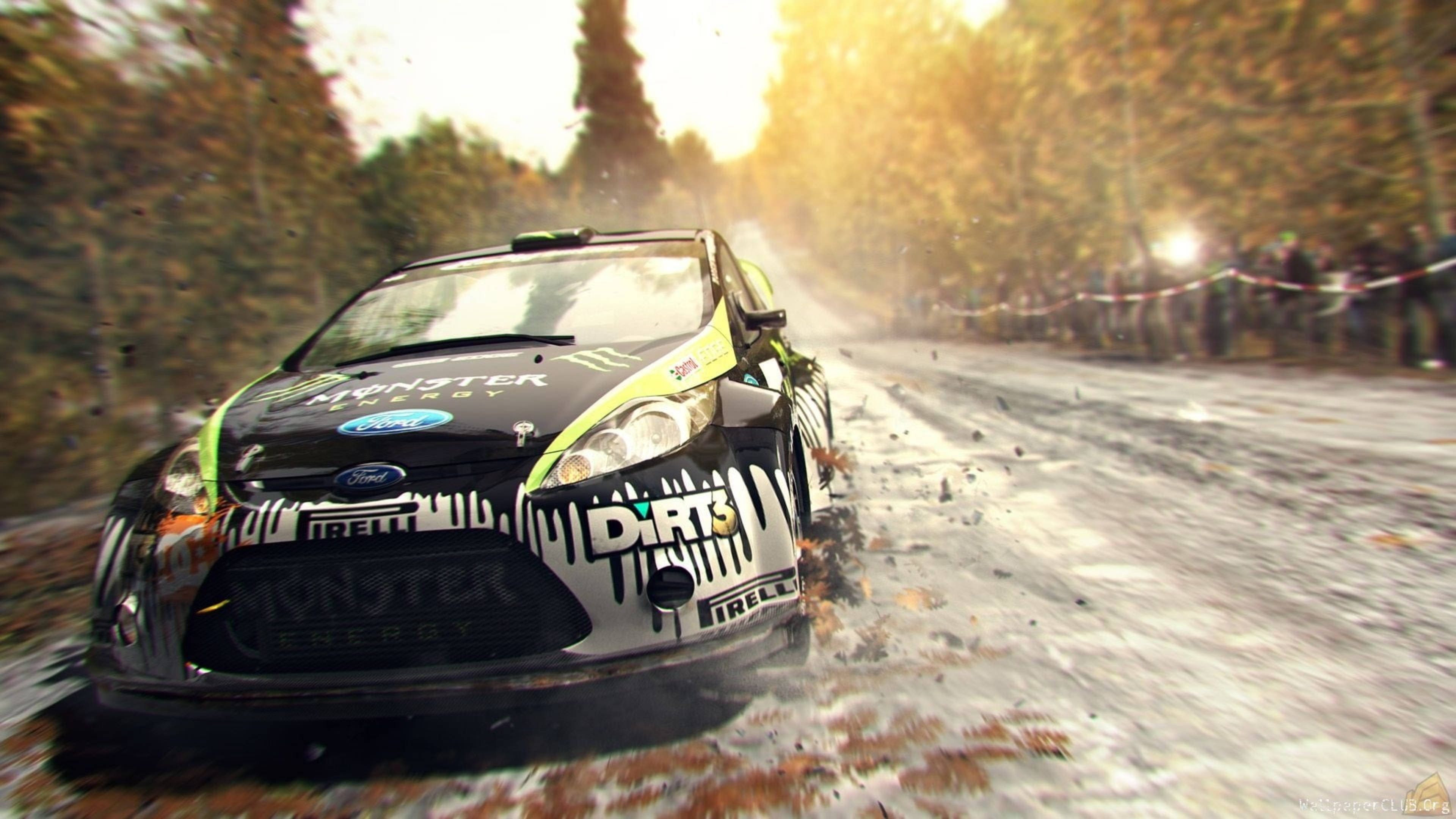 《Dirt 3》福特日出 壁紙 — 一輛黑綠色的拉力賽車在泥濘的森林賽道上飛馳，在金色陽光下激起水花。