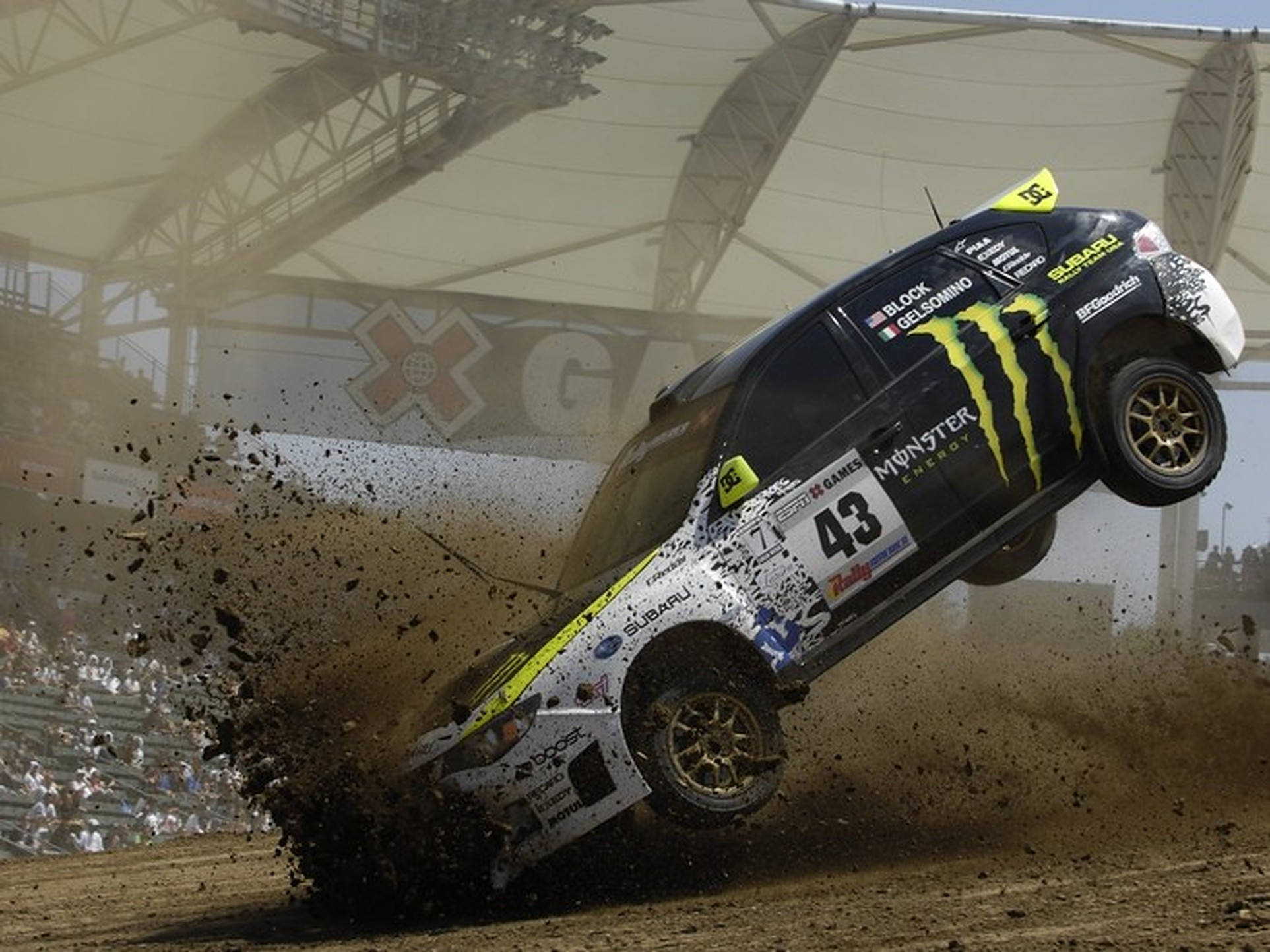 Dirt 3 跳躍撞擊 壁紙 — 一輛黑黃色的拉力賽車在泥地賽道上飛躍，在體育場燈光下濺起泥漿。