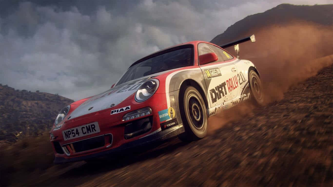 準備好在《Dirt Rally》中猛踩油門 壁紙 — 一輛紅白相間的拉力賽車在多塵的山地地形中疾馳，在陰天揚起塵土。