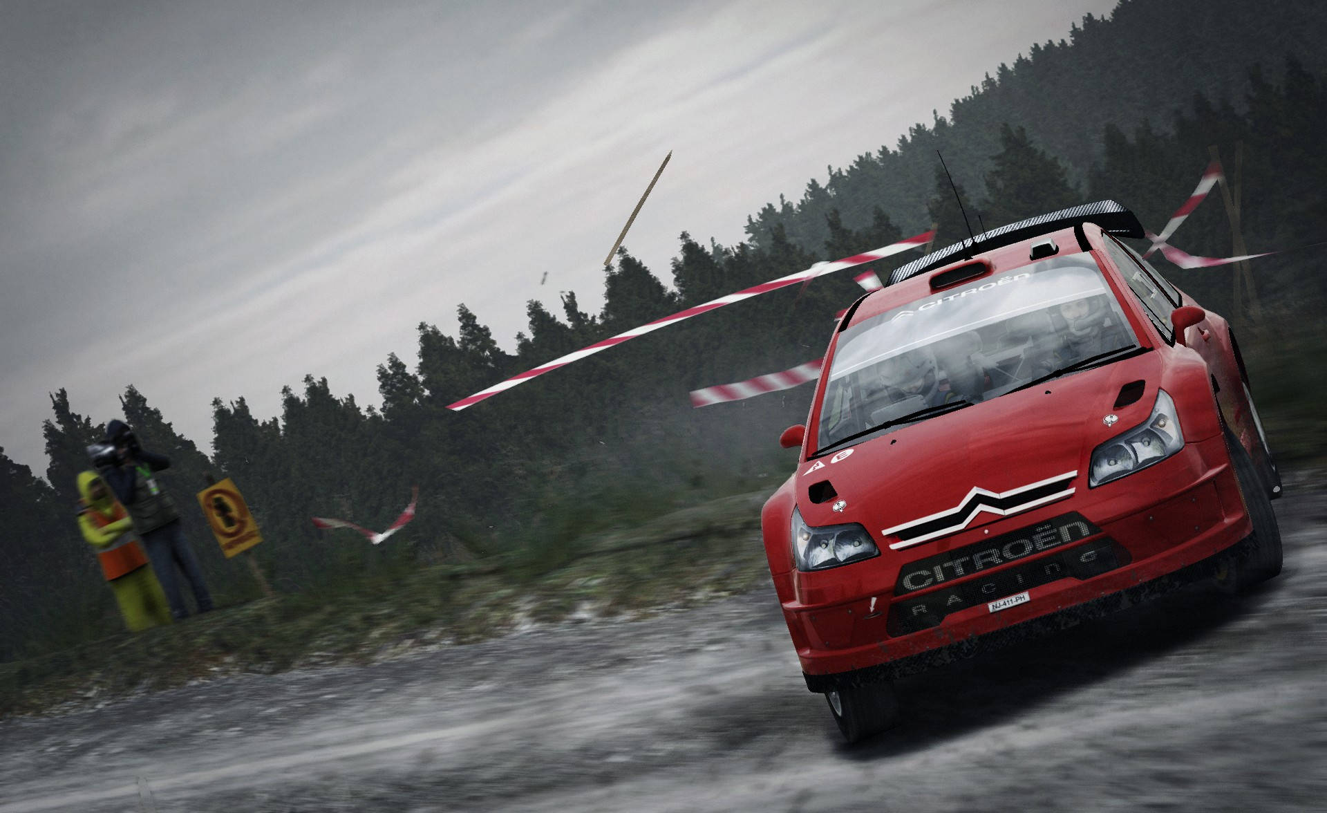 《Dirt Rally》紅色Citroën賽車 壁紙 — 一輛紅色雪鐵龍拉力賽車在泥濘的林間賽道上飛馳，紅色和白色的障礙物在風中飛舞。