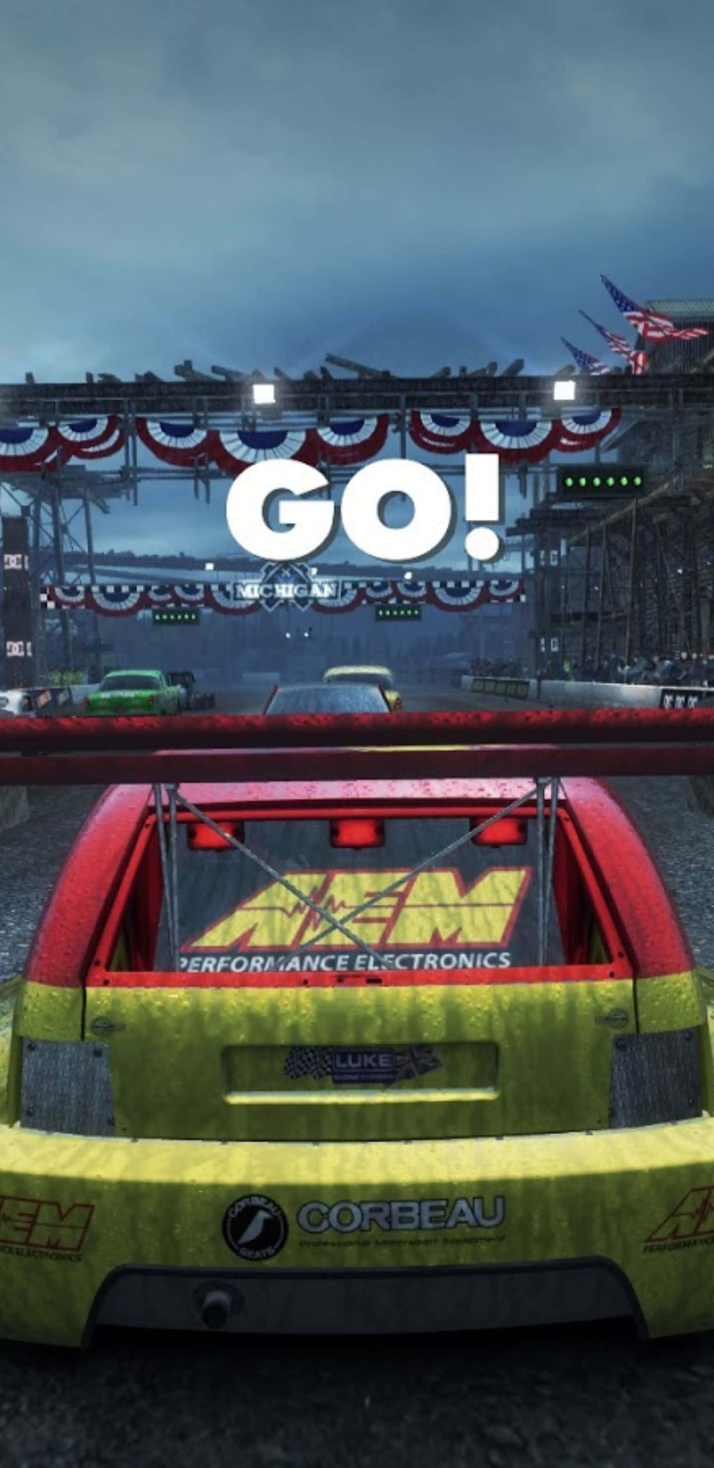 Dirt Showdown Go! 記號背景 壁紙 — 在密歇根州潮濕的賽道上，一輛充滿活力的賽車上方有「GO!」標誌，天空多雲。