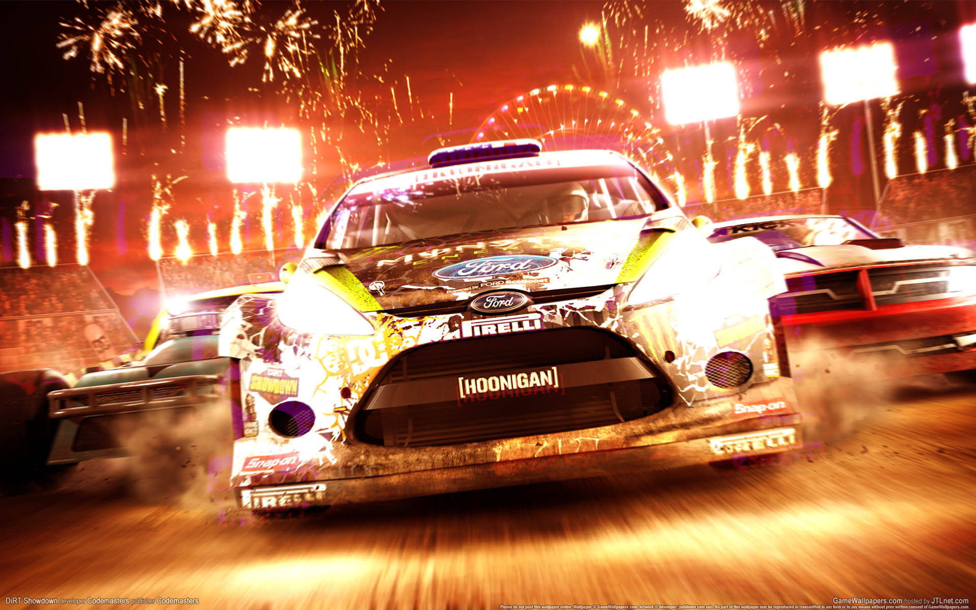《Dirt Showdown》遊戲畫面 壁紙 — 一輛帶有「Hoonigan」品牌的福特拉力賽車在煙火和體育場燈光下於夜間賽道上飛馳。
