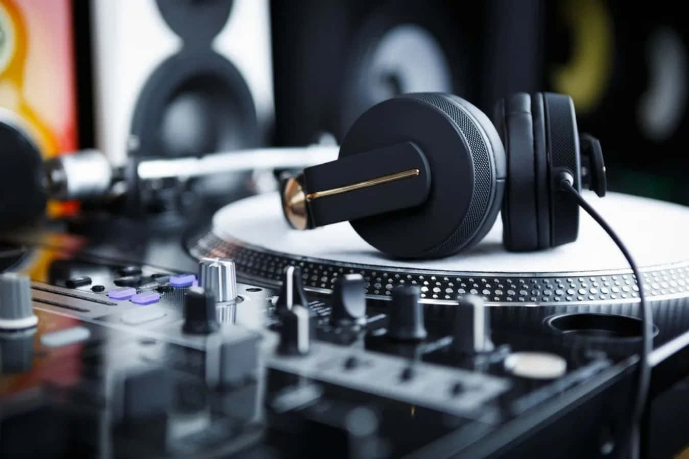 DJ音樂設置轉盤與耳機圖 壁紙 — 黑色DJ耳機放在唱盤上，前方有一個時尚的混音器。