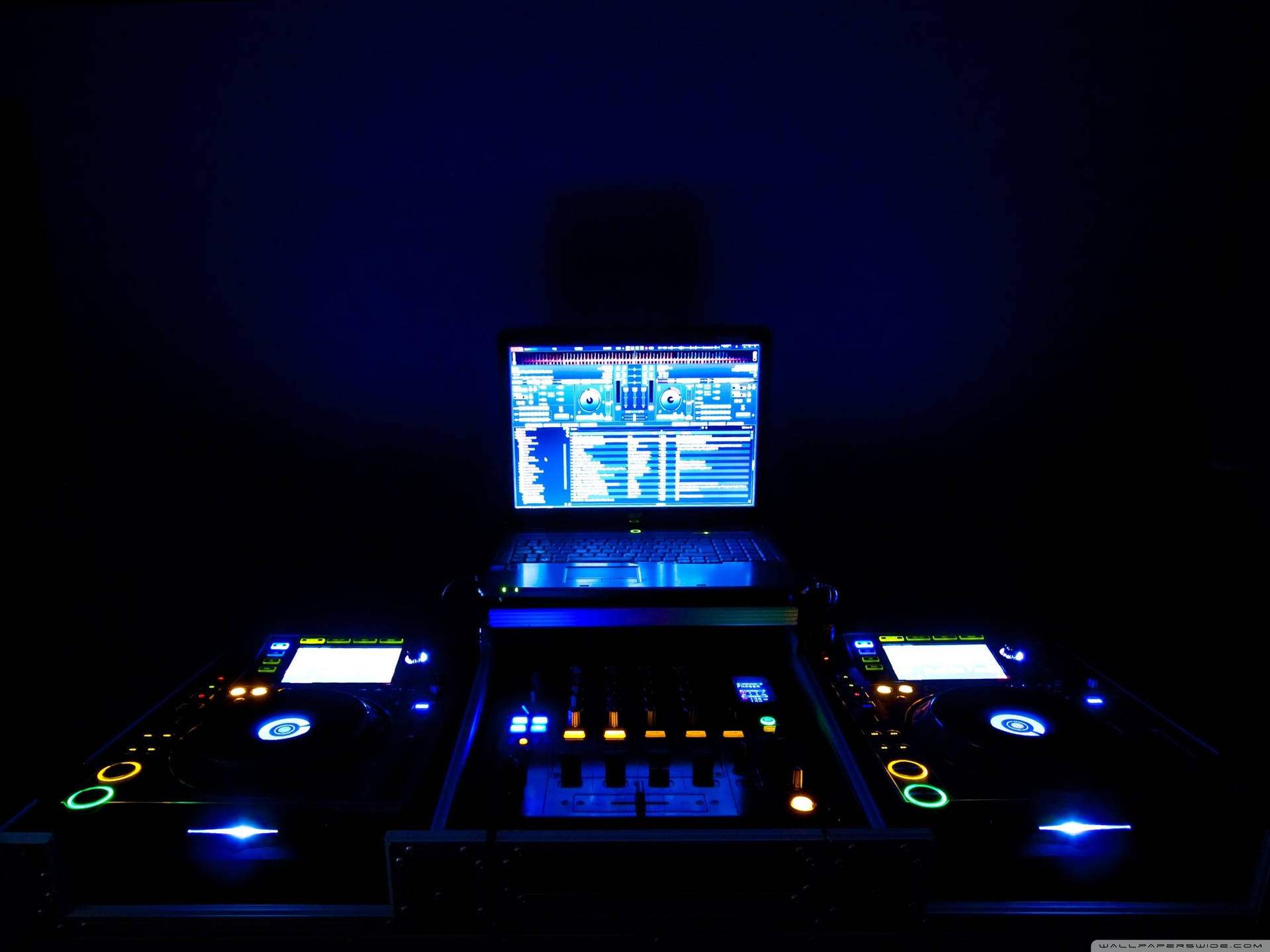 在黑暗的房間中發出藍色和橙色光芒的 DJ 設備。