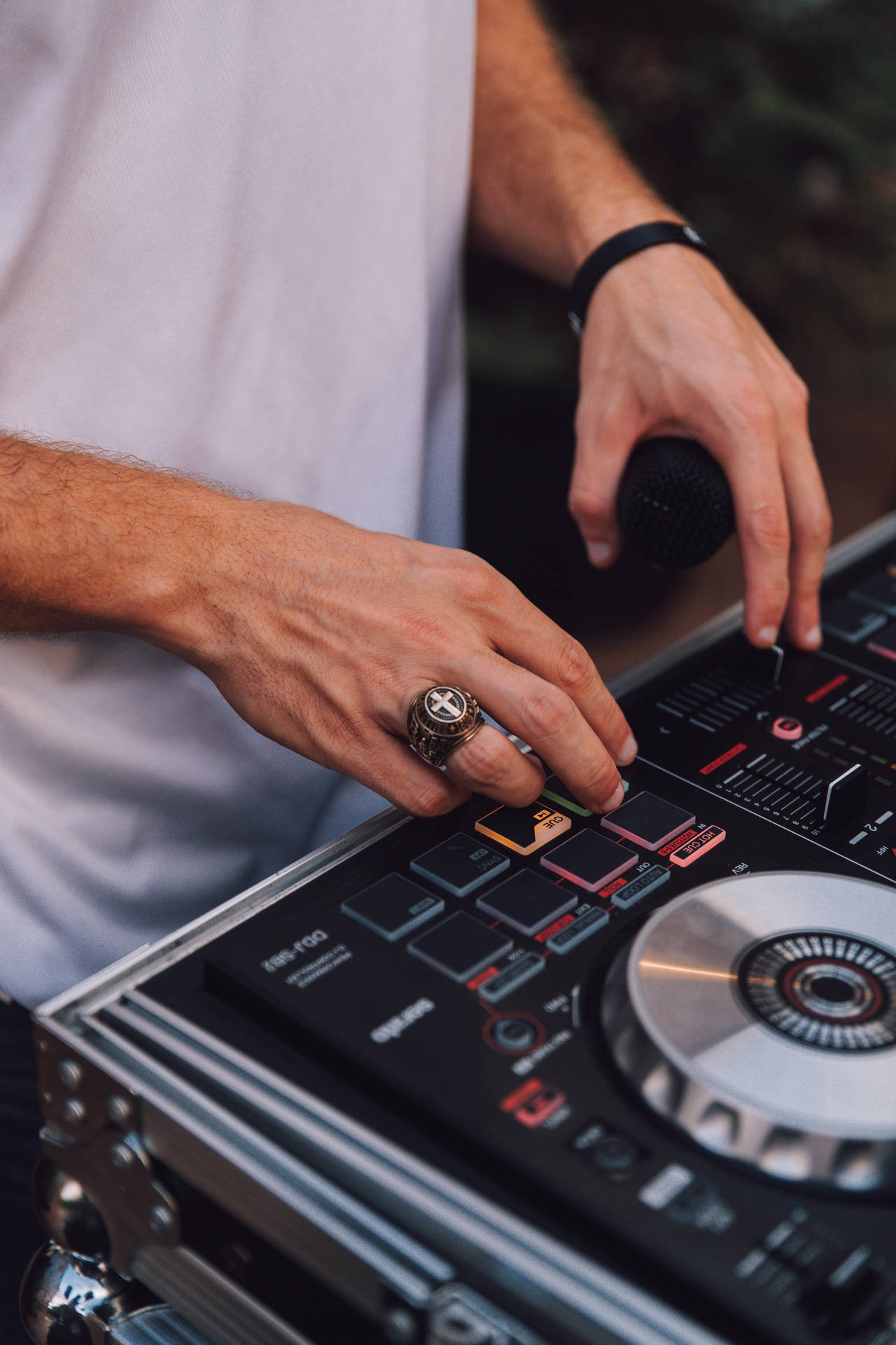 DJ雙手在專業混音台上調整控制。