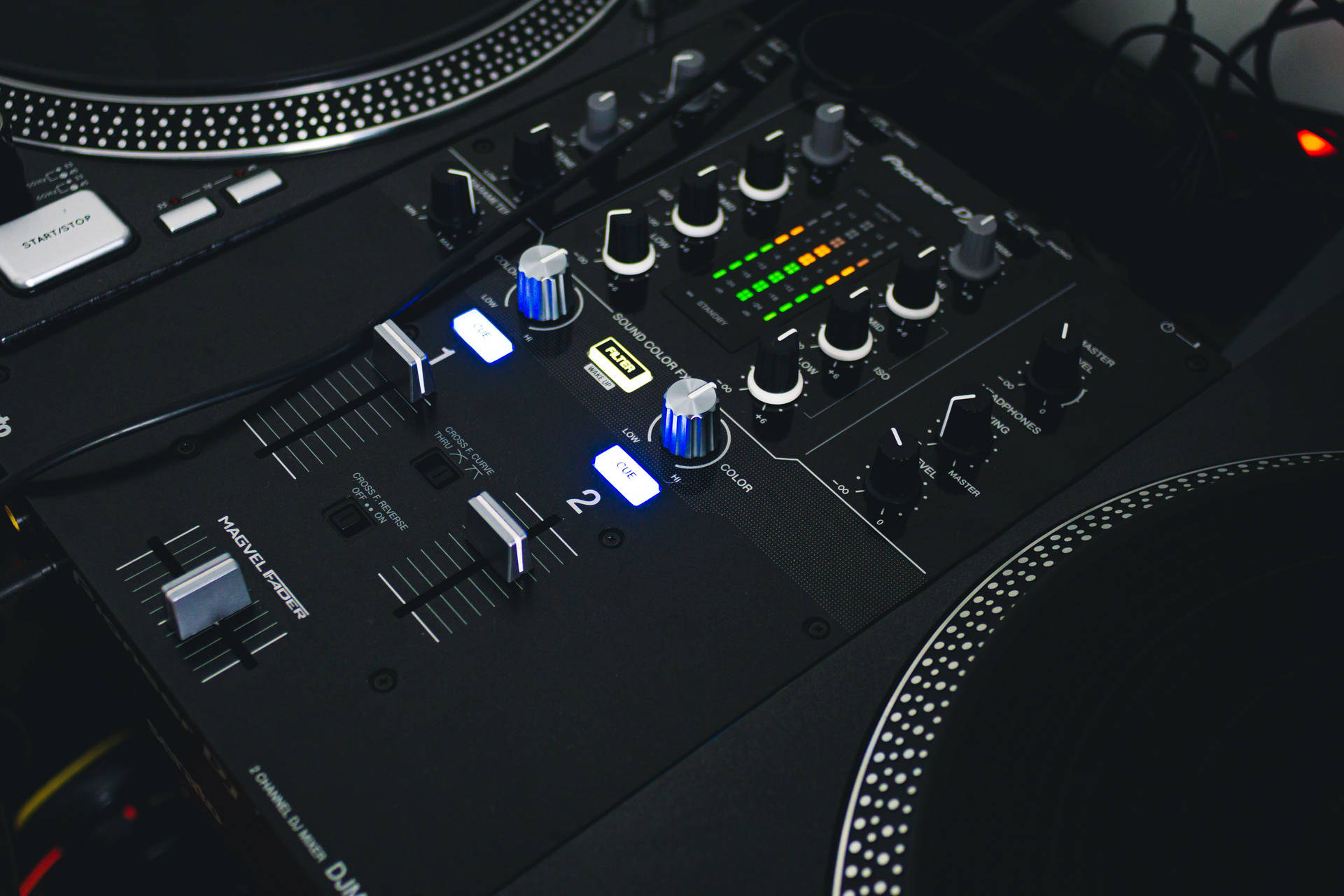 專業DJ混音器，在黑暗的工作室中配有照明控制和唱盤。