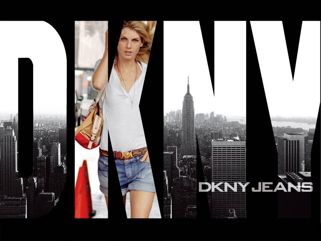 DKNY標誌與女性 壁紙 — 一位穿著牛仔短褲和白色上衣的女性自信地站在黑白紐約市天際線前，帝國大廈清晰可見。