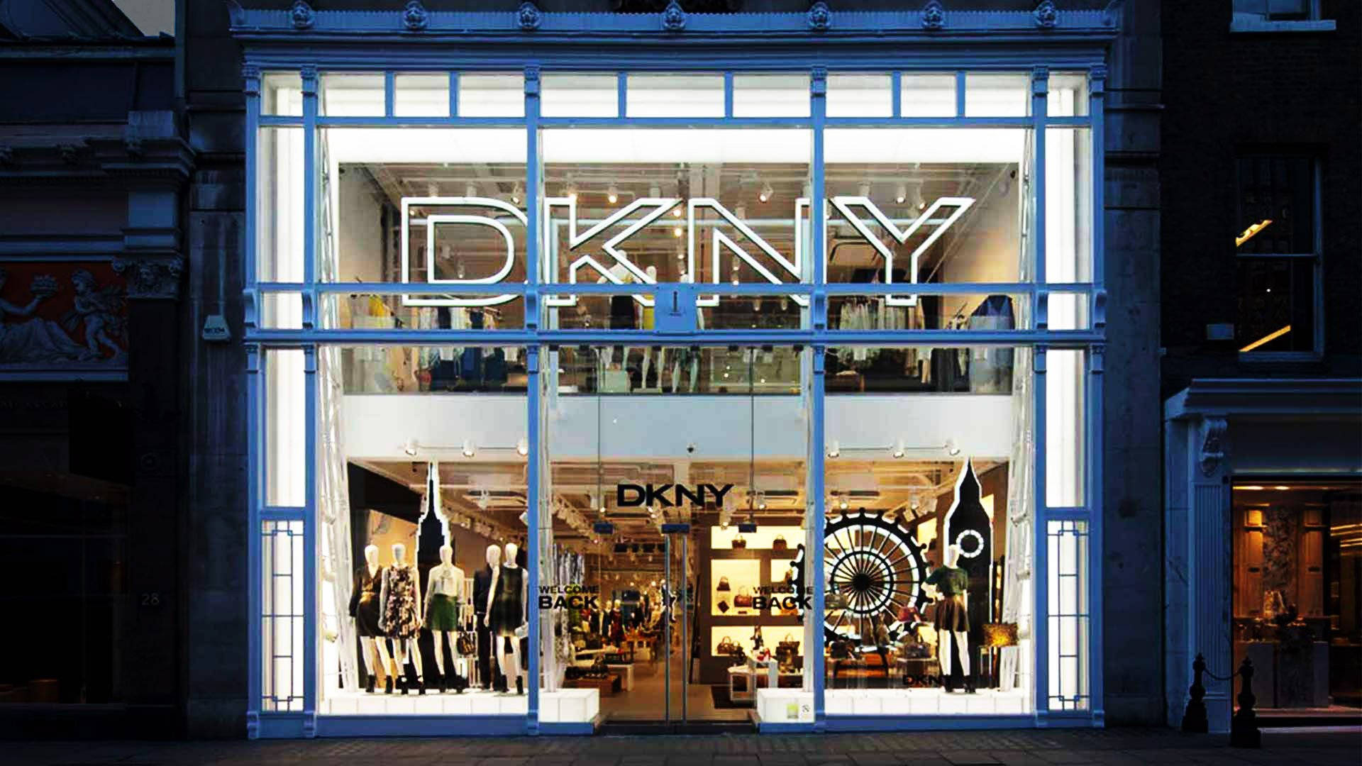夜晚DKNY時尚商店櫥窗展示，模特兒和發光招牌。