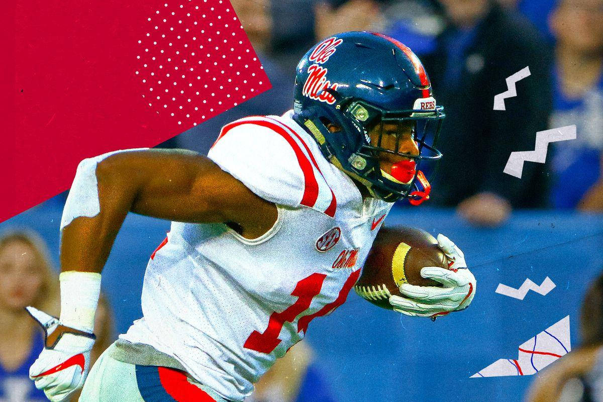 DK麥特卡夫賽場疾跑 壁紙 — 一名穿著 Ole Miss 裝備的美式足球員在動態圖形疊加和模糊的體育場人群中持球衝刺。