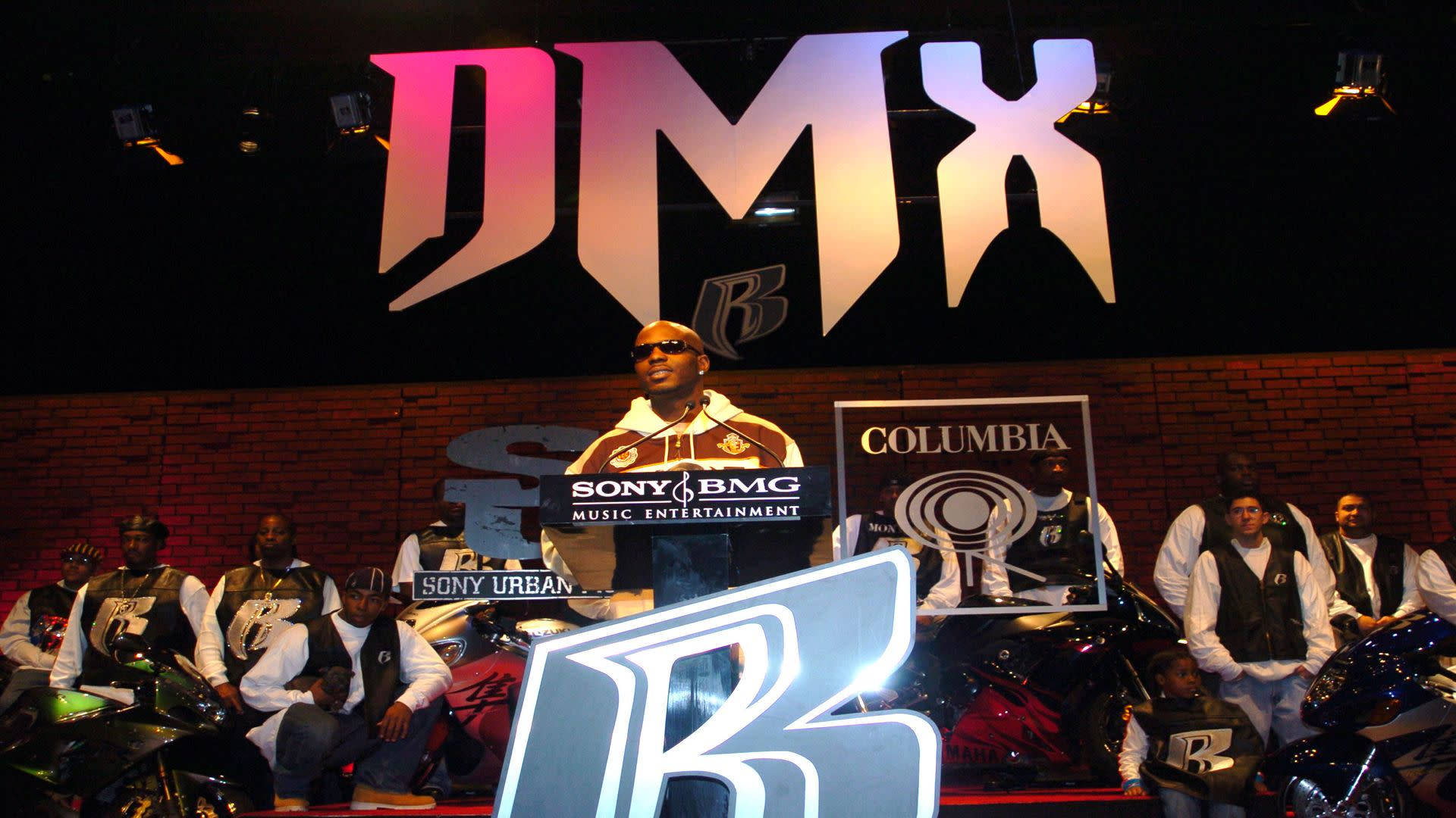 DMX 在一個大型 DMX 標誌下與他的團隊和摩托車參加音樂活動。