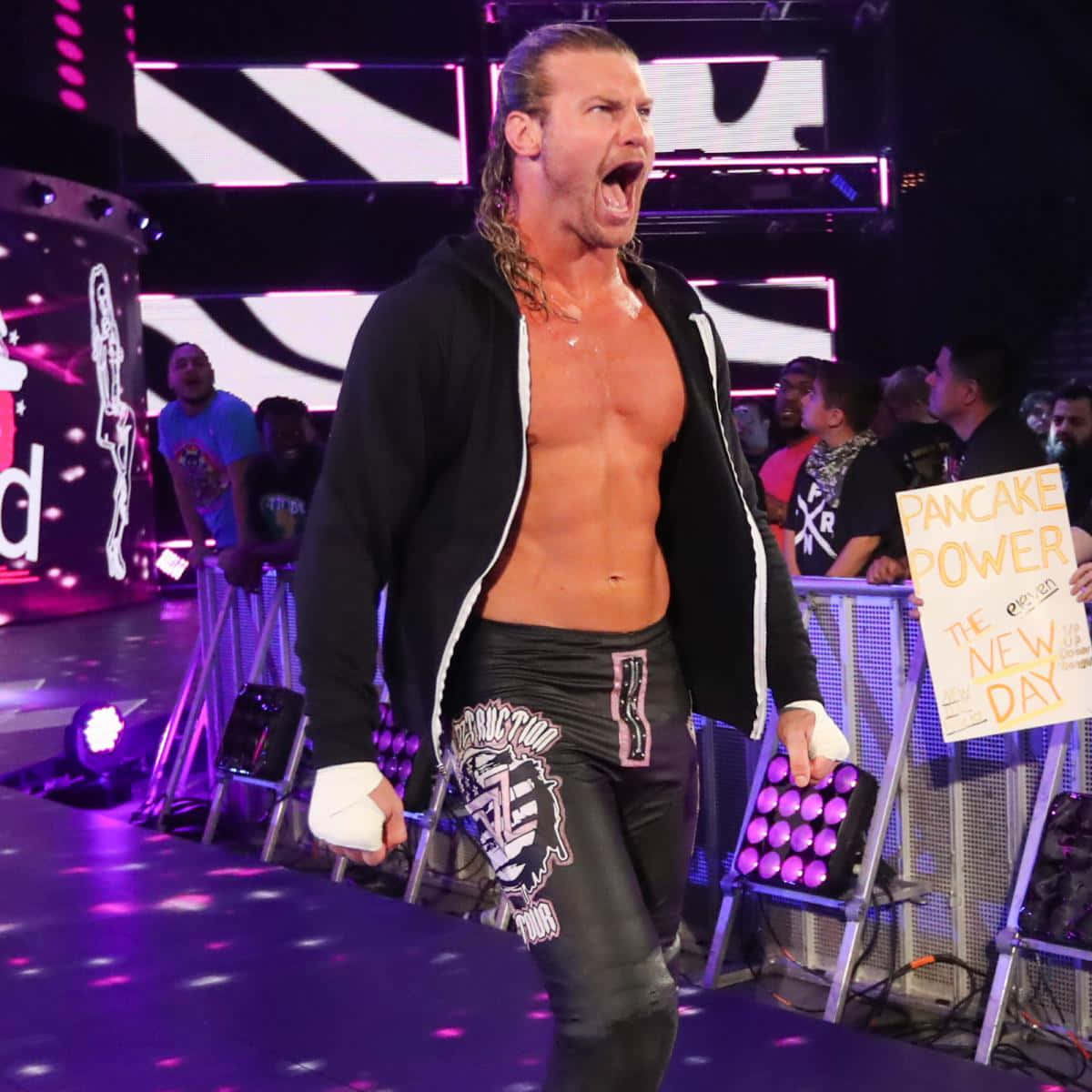Dolph Ziggler 第22屆三冠王 壁紙 — 一位肌肉發達的長髮摔角手在紫色燈光的舞台上勝利地咆哮，粉絲們歡呼並舉著標語牌。