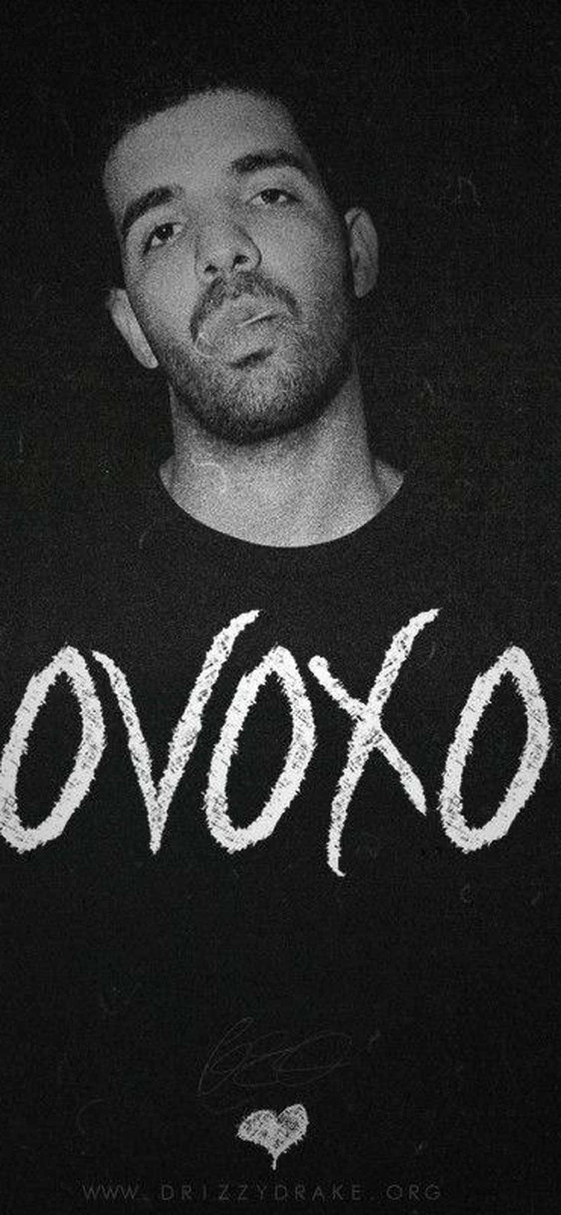 Drake 黑白照，身穿印有 OVOXO 文字的襯衫。