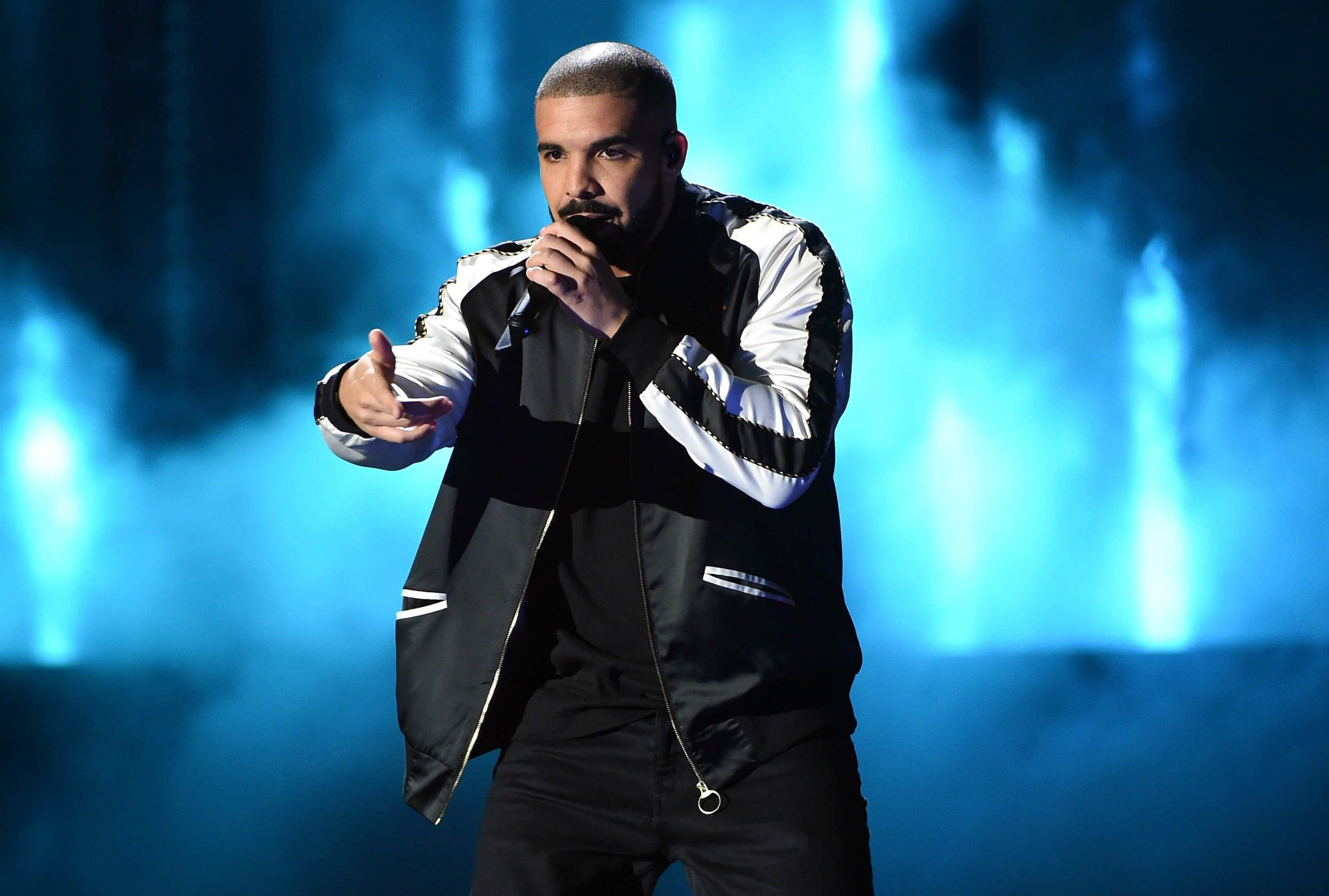 Drake 桌布 壁紙 — Drake 身穿黑白外套，在充滿活力的藍色舞台燈光和煙霧中表演。