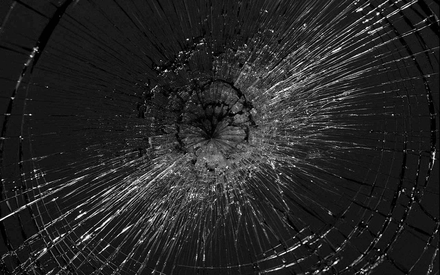 從中央撞擊點放射出裂紋的破碎玻璃（黑白）。 — 裂屏 壁紙