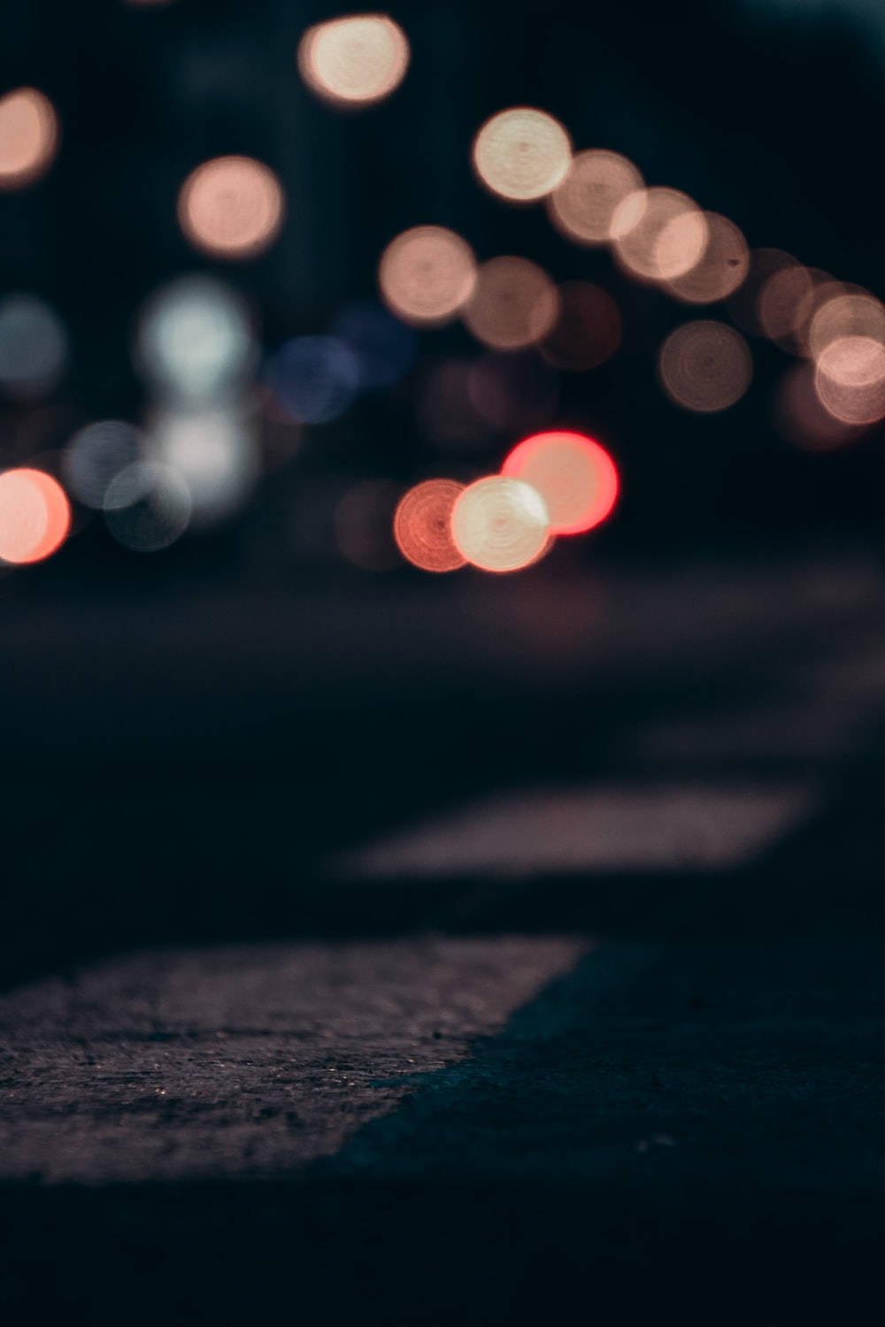 夜晚街道，帶有發光的散景燈光和黑暗的紋理人行道。