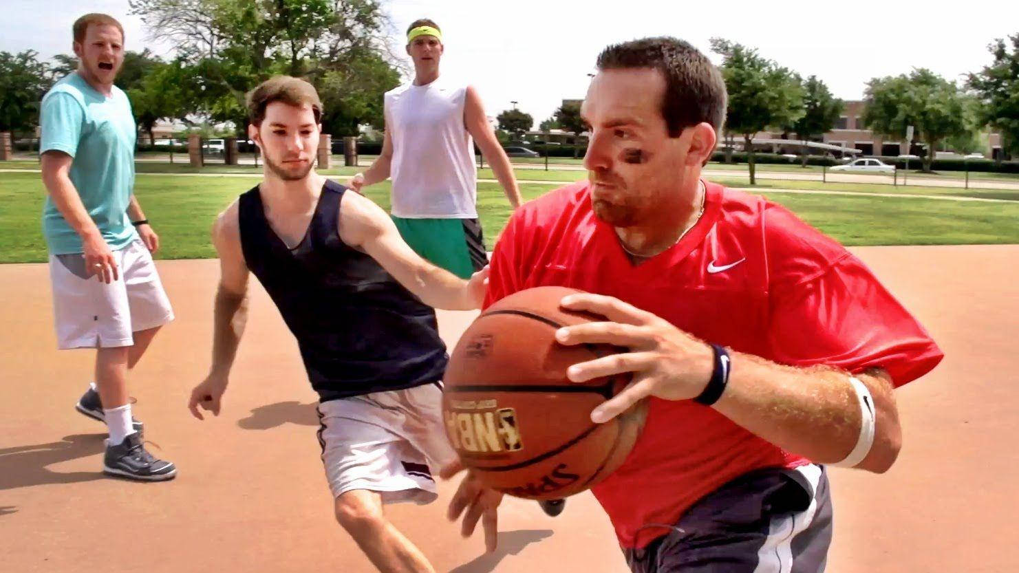 Dude Perfect 面部彩繪打籃球 壁紙 — 一名身穿紅色襯衫的男子在戶外球場運球，背景中有另外三名球員防守他。