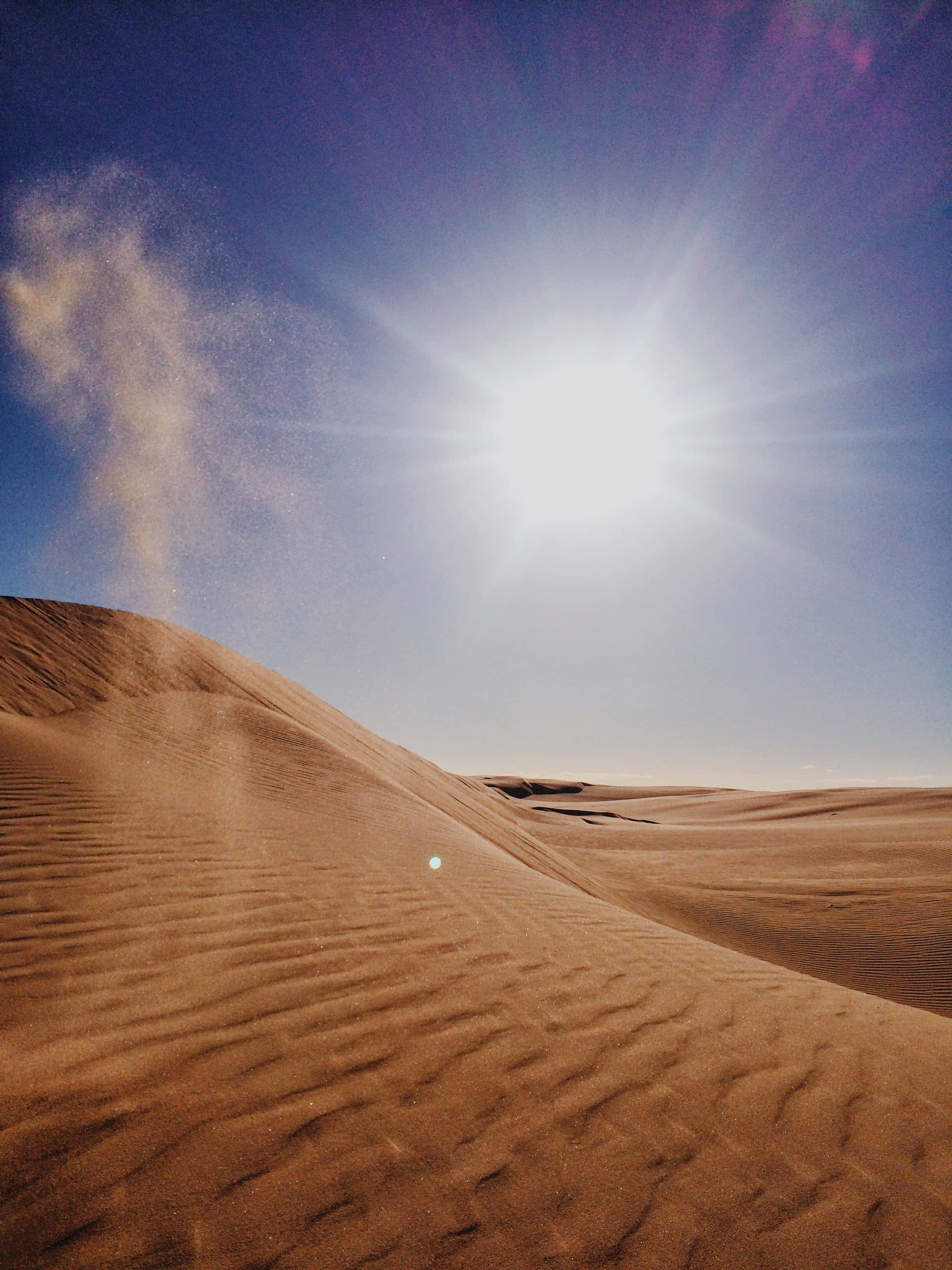 保羅·亞特雷德與查妮穿越Dune沙漠 壁紙 — 廣闊的沙漠景觀，波紋狀的沙丘在明亮的陽光下，產生耀眼的光芒四射效果。