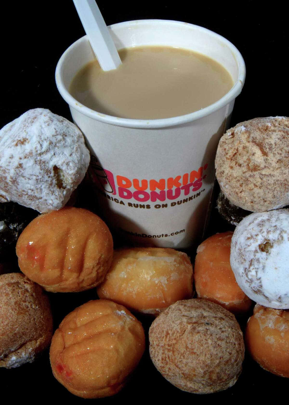 以美味Dunkin' Donuts點心，開啟美好一天！ 壁紙 — 一個Dunkin' Donuts咖啡杯，周圍放滿各種糖霜和糖粉冬甩，背景為黑色。