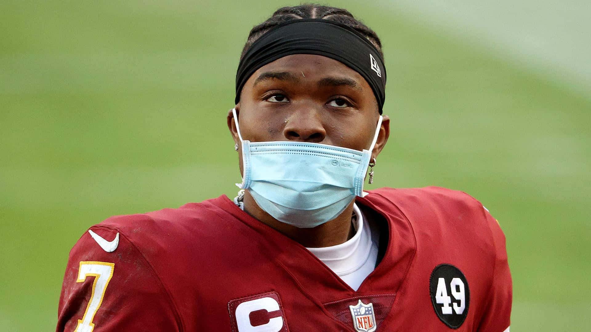 NFL足球運動員在草地上戴著面罩和紅色球衣，號碼49。