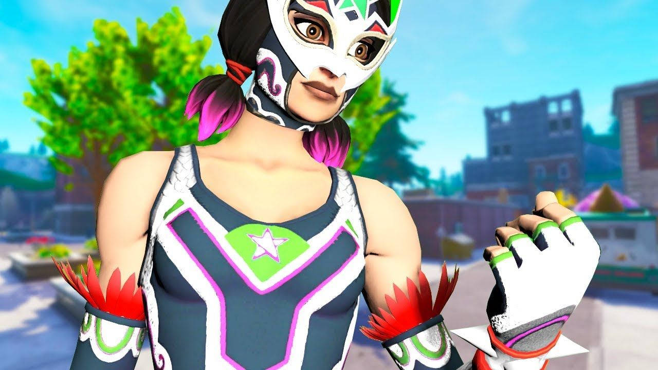 Dynamo《Fortnite》縮圖壁紙 壁紙 — 一位充滿活力的女摔角手，戴著彩色面具和飾有星星的服裝，自信地站在陽光明媚的城市環境中。