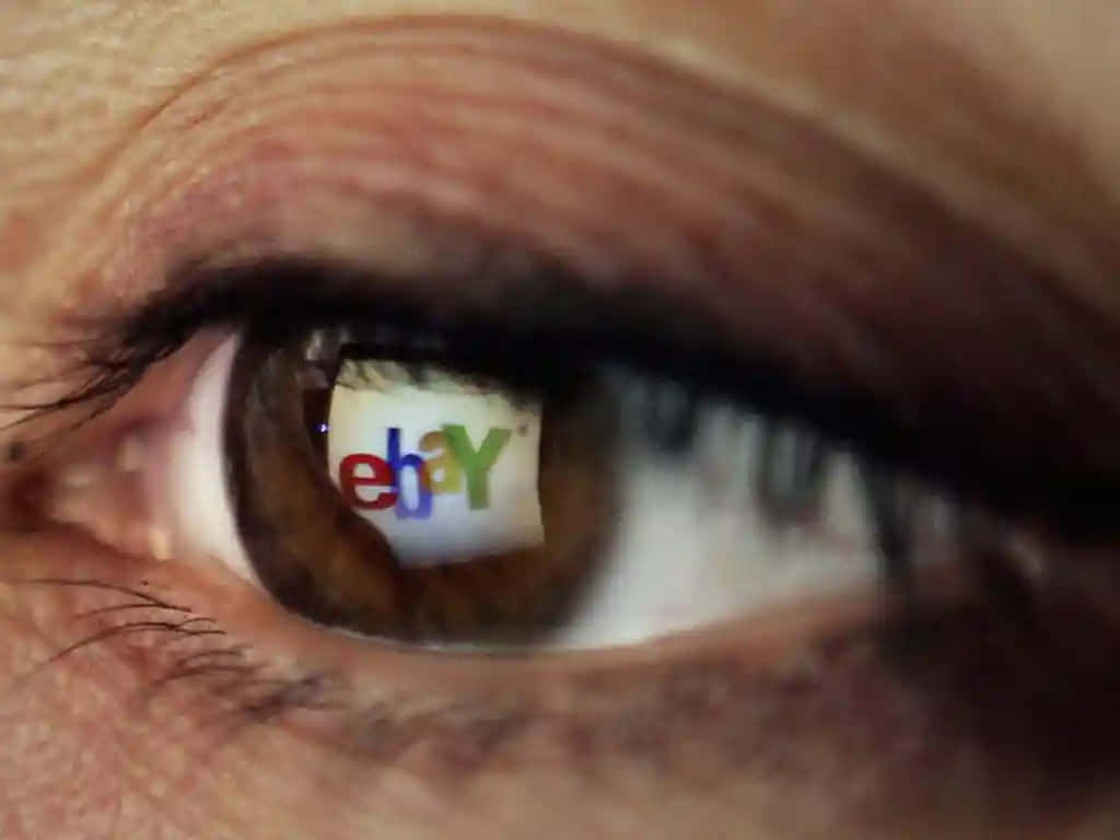 eBay UK 標誌倒影 壁紙 — 人類眼睛的特寫，虹膜中反射出色彩繽紛的eBay標誌。