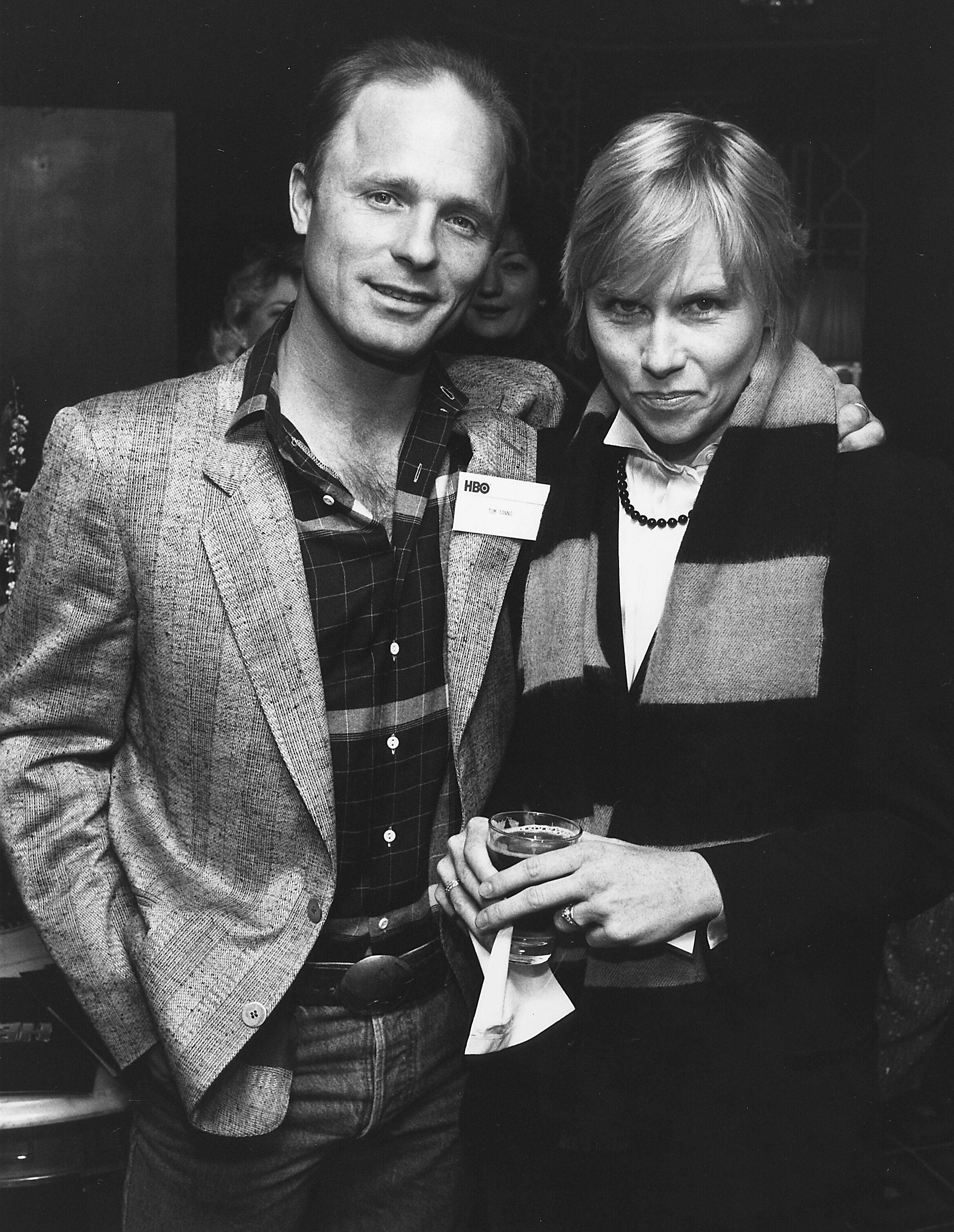 美國演員Ed Harris與妻子Amy Madigan 壁紙 — 一張黑白照片，一男一女在社交活動中拿著飲品一起擺姿勢。