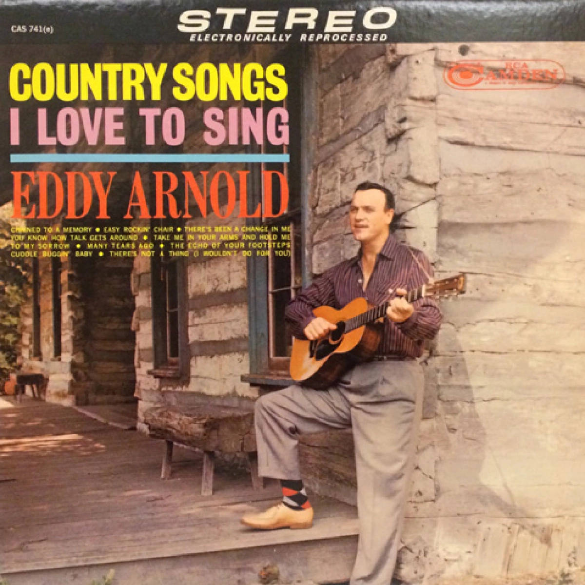 Eddy Arnold 在復古鄉村音樂專輯封面中，在質樸的小屋門廊上彈奏結他。
