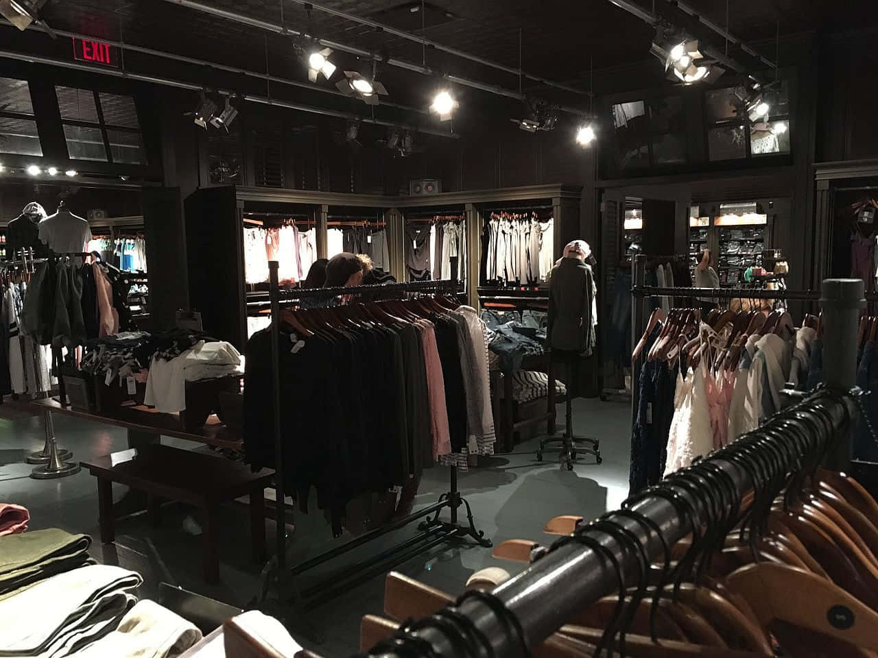 聚光燈下帶有衣架和模特兒的黑暗精品店。