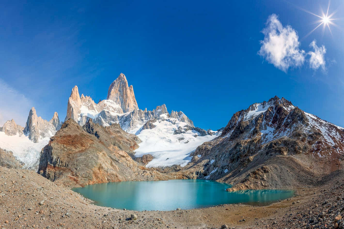 El Chalten的美麗天堂 壁紙 — 一個令人驚嘆的山脈，有白雪覆蓋的山峰和一個碧綠色的湖泊，在明亮的藍天下有一朵雲。
