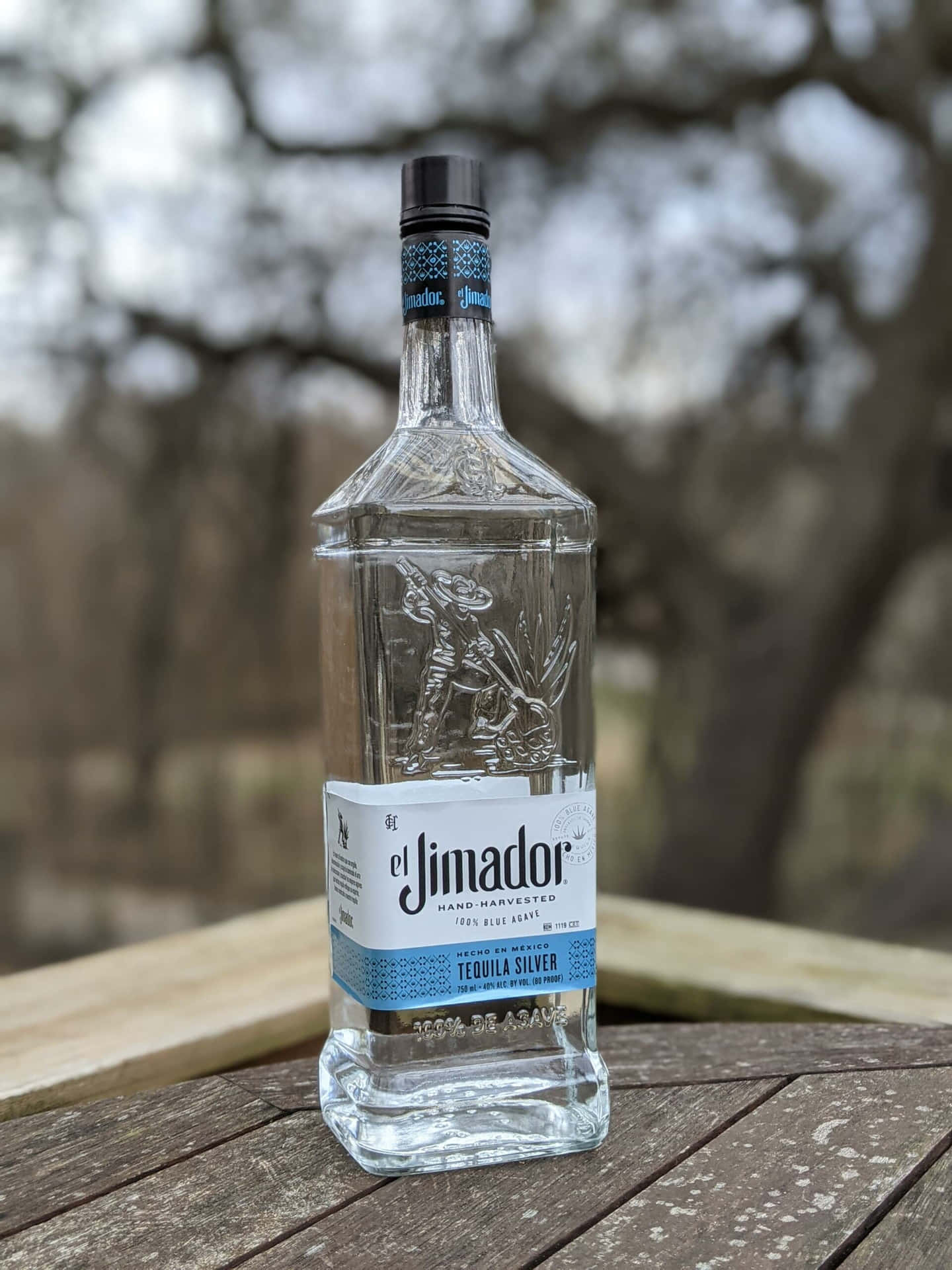 戶外木桌上的 El Jimador 龍舌蘭酒瓶
