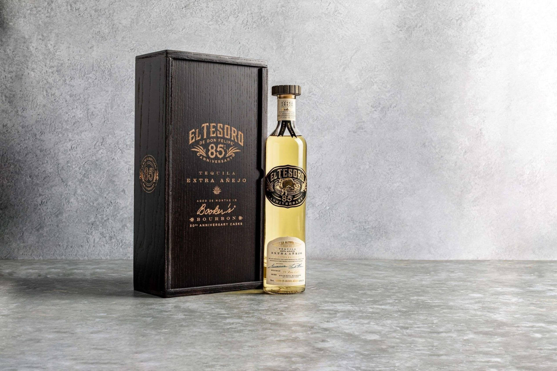 El Tesoro 88 Tequila Extra Añejo酒瓶和木盒放在灰色混凝土表面上。
