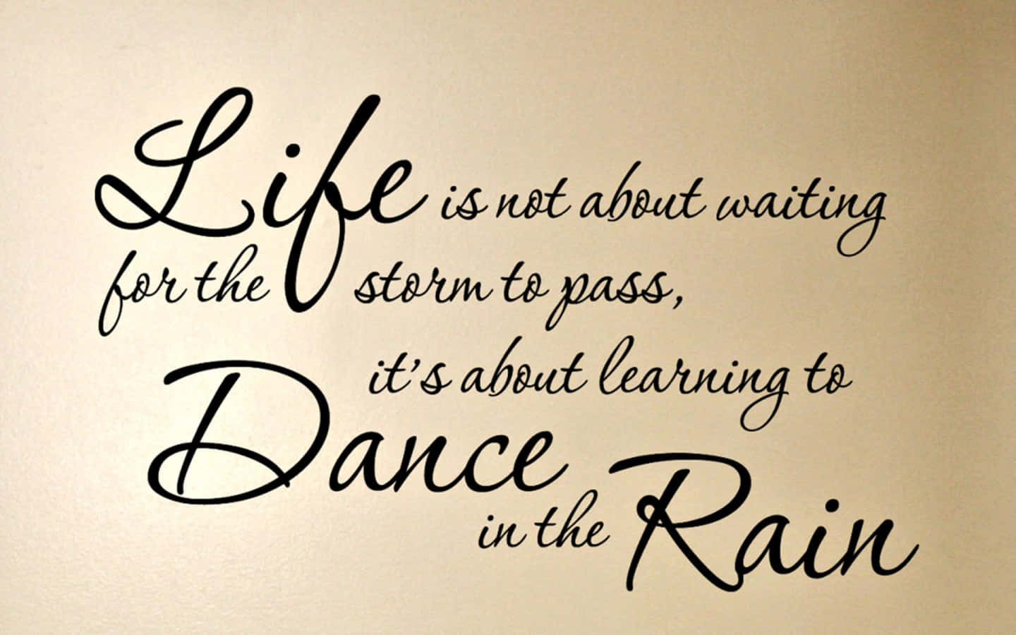  壁紙 — 米色牆上優雅的黑色草書名言寫著「Life is not about waiting for the storm to pass, it's about learning to Dance in the Rain」。
