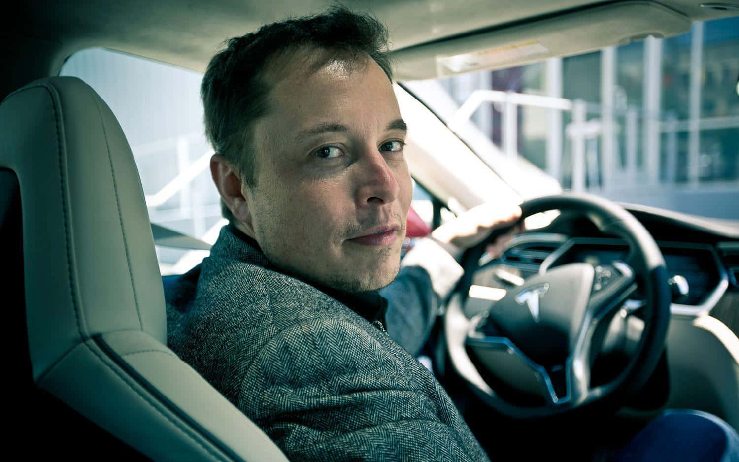 馬斯克 桌布 壁紙 — Elon Musk 坐在一輛 Tesla 車內，冷靜地直視鏡頭。