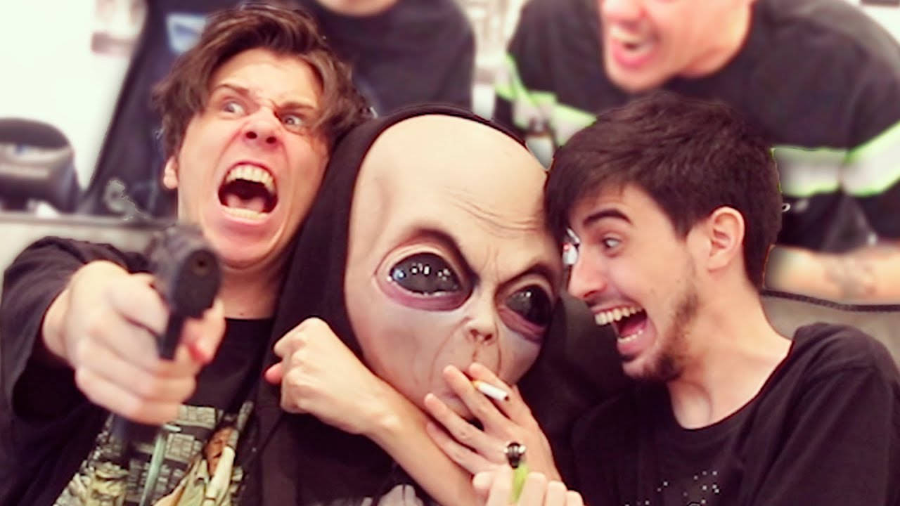 ElRubiusOMG挑戰外星主題！ 壁紙 — 三個男人在一個混亂幽默的場景中，其中一個戴著外星人面具，手持香煙，另一個則用玩具槍指著。