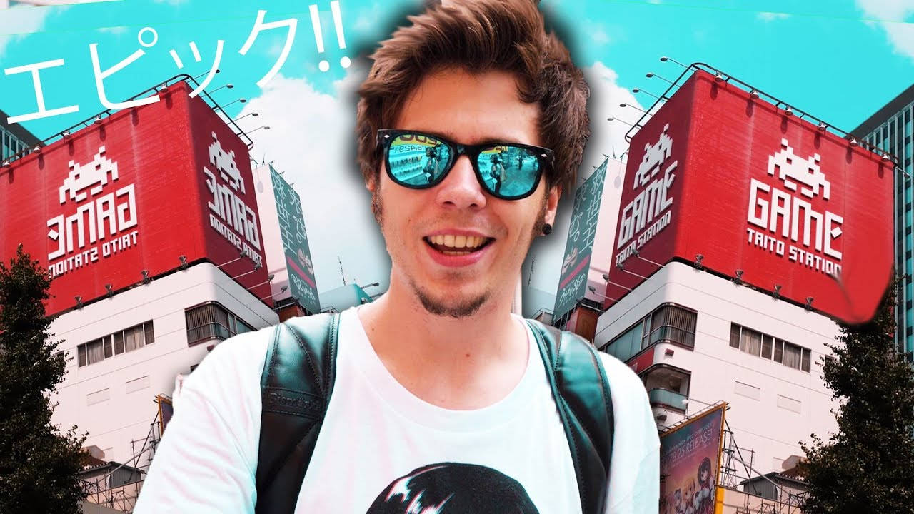 戴太陽眼鏡的年輕男子在遊戲廳前微笑。