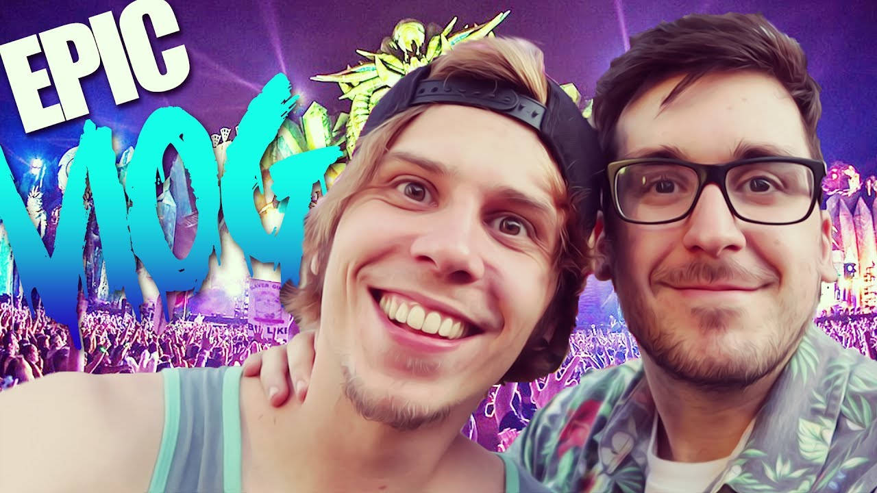 ElrubiusOMG與Mangel維加斯Vlog 壁紙 — 兩個微笑的男人在充滿活力的紫色演唱會上自拍，身後有發光的舞台燈光和人群。