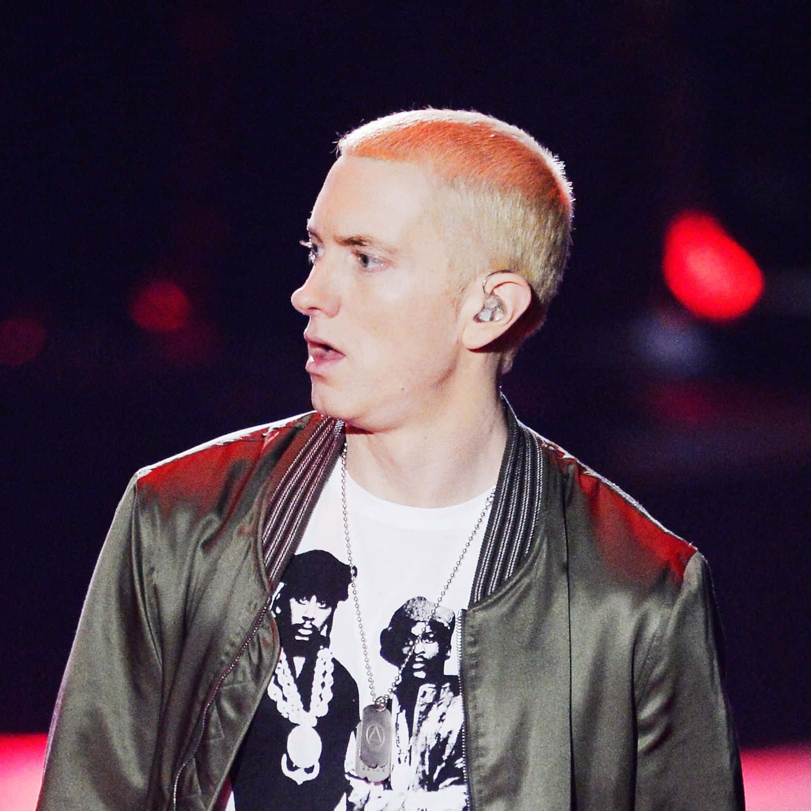 Eminem 桌布 壁紙 — Emil eminem 在紅色舞台燈光下，以橙色頭髮和轟炸機夾克表演。