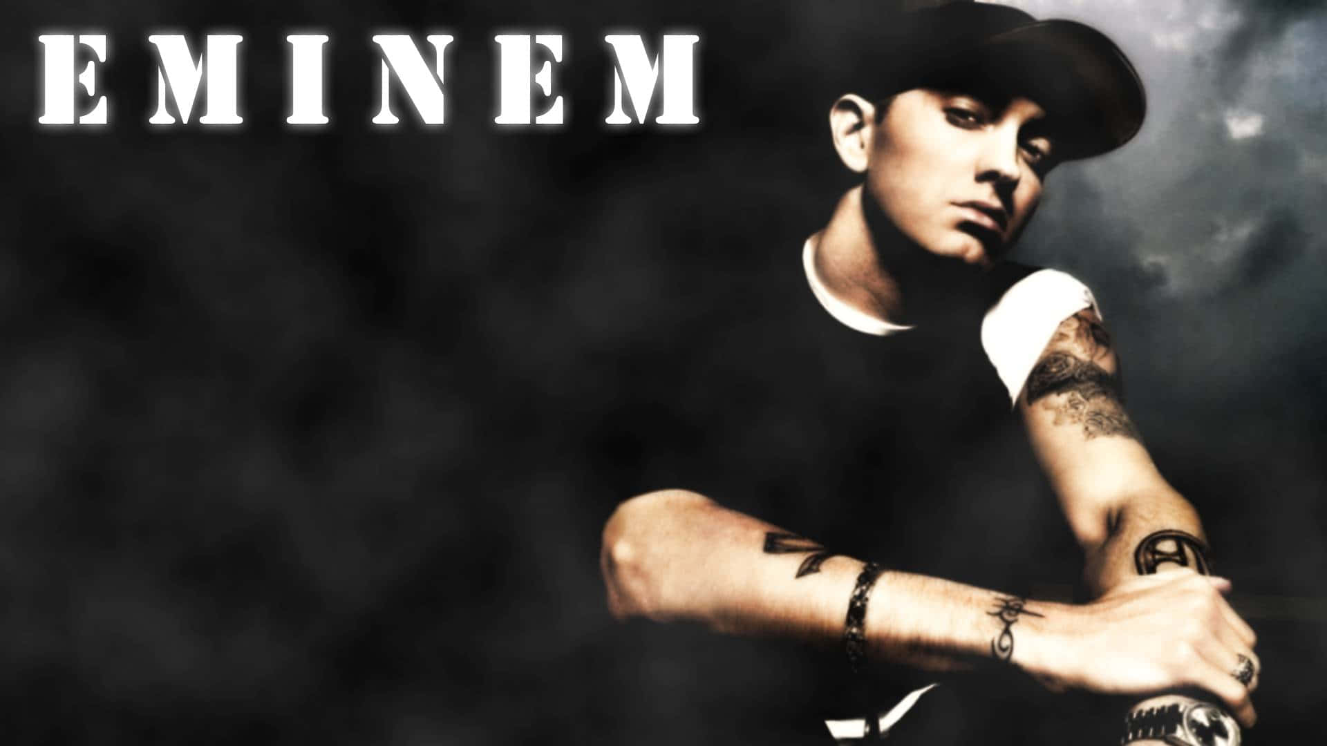Eminem 桌布 壁紙 — Eminem 在昏暗煙霧背景及戲劇性燈光下，交叉雙臂，眼神凌厲。